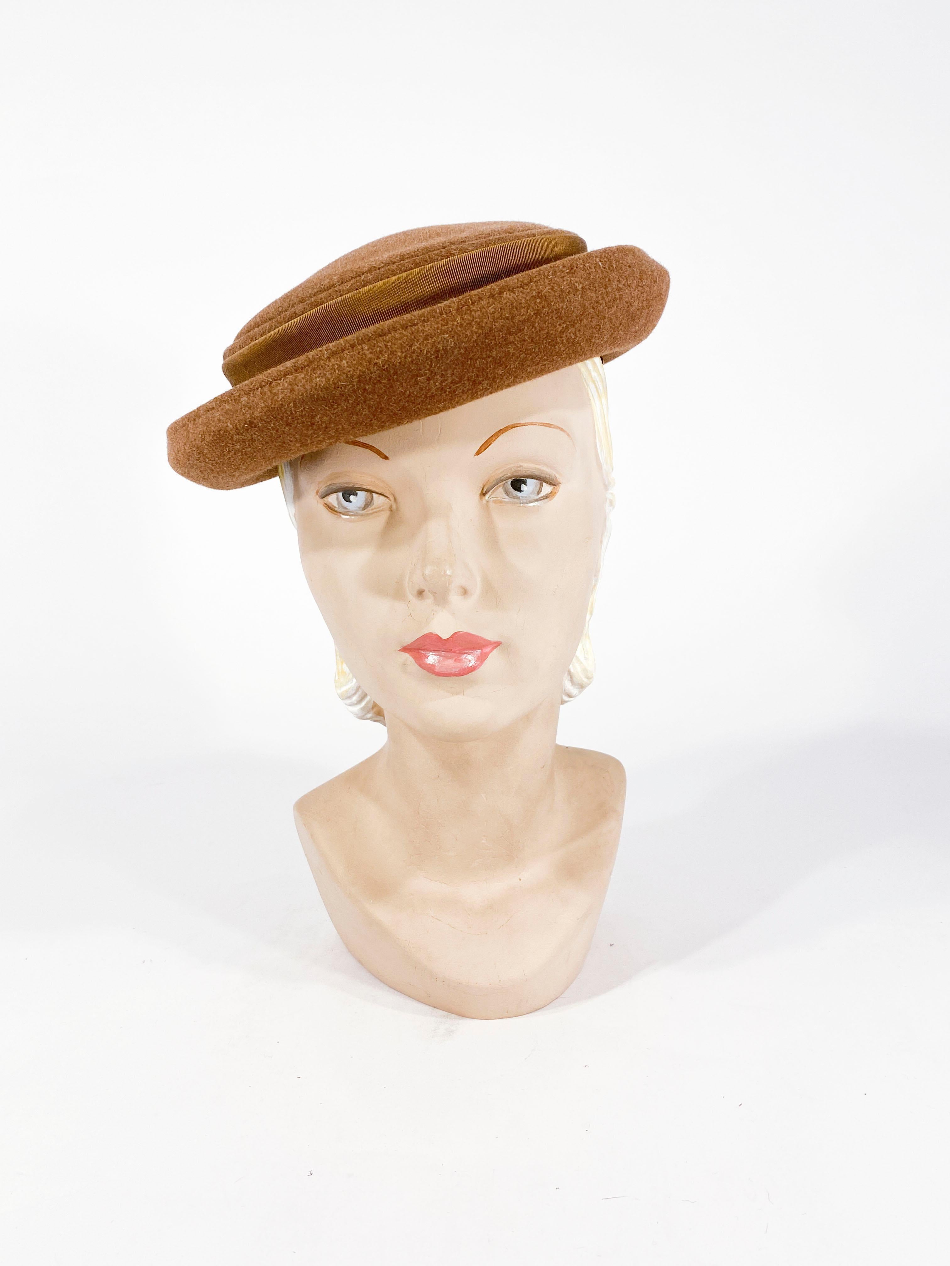 Late 1940s to Early 1950s taupe-colored beaver fur felt hat with hand rolled brim and the crown is finished with a grosgrain band and bow.