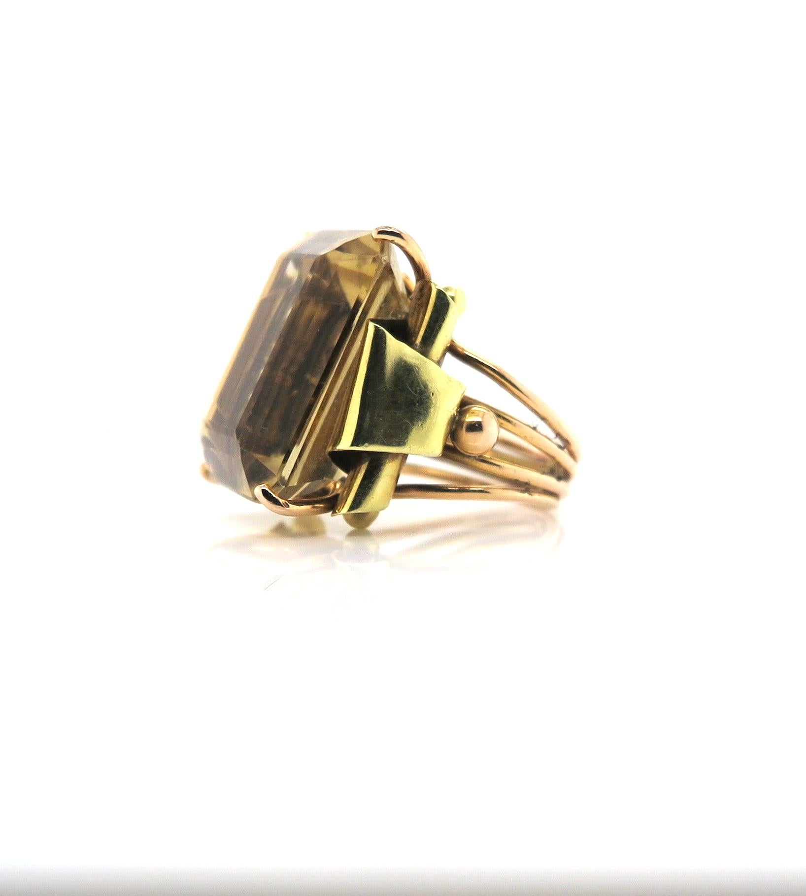 Featuring a 35 carat Citrine ring, circa 1940s, American. Set in 18K yellow and rose gold, this stunning forties ring features a gorgeous, rectangular 35 carat natural golden Citrine. The beautiful detailing in gold and the bold geometric design