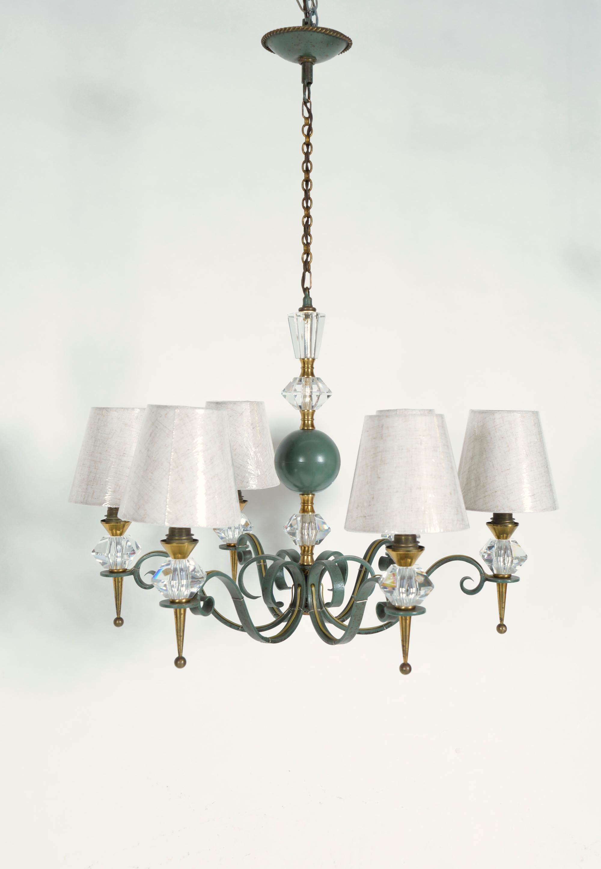 Un bel exemple de lustre décoratif français d'après-guerre conçu par la célèbre société Genet et Michon. Cet exemplaire est fabriqué en acier forgé, en laiton et en cristal, les éléments en verre étant fabriqués par Cristal de Sèvres. Les pièces en