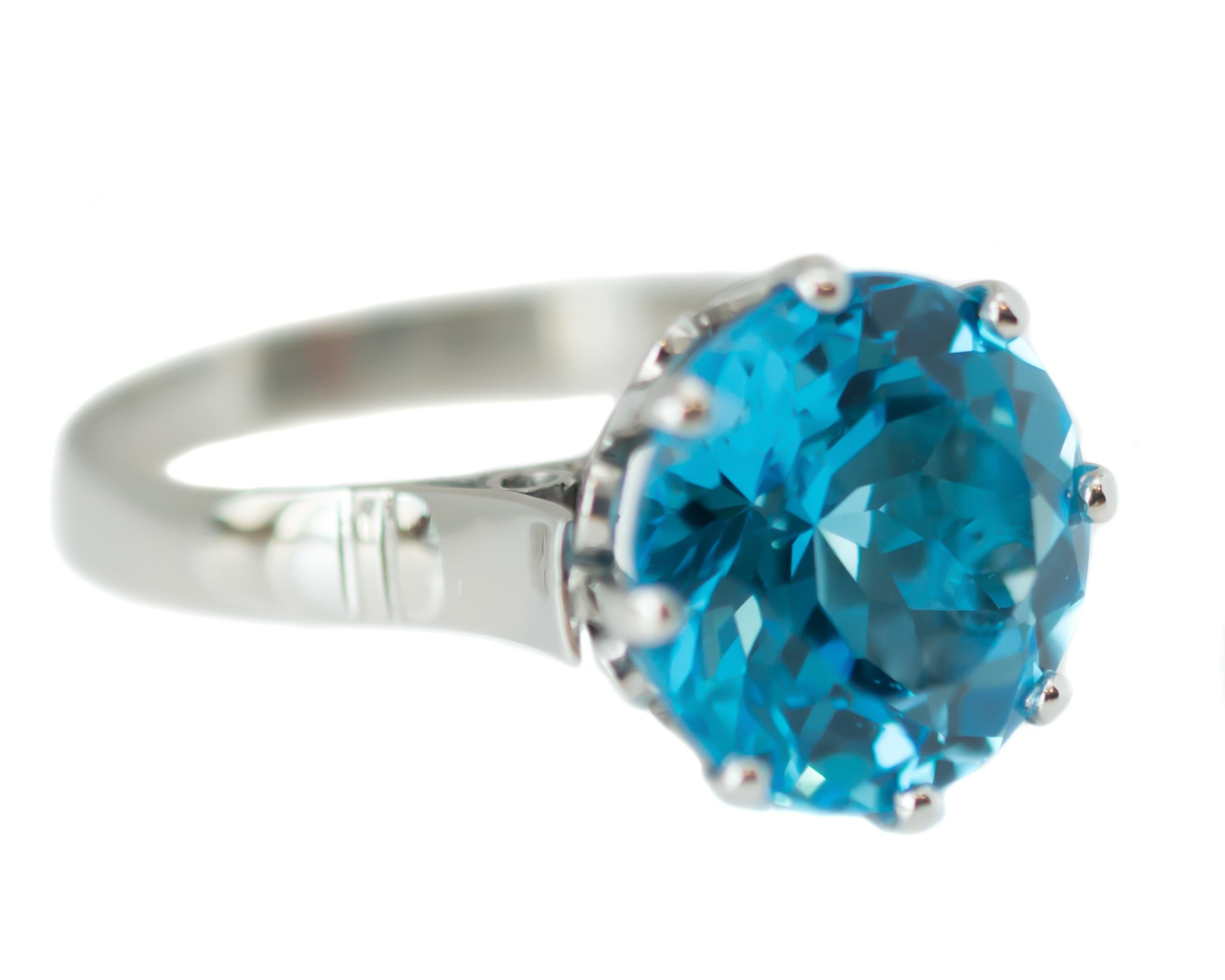 1940s Retro London Blue Topaz Solitaire Ring - Platinum, London Blue Topaz

Features:
8.5 Carat Round London Blue Topaz
Platinum Setting
8-Prong Setting
Decorative Cathedral Setting
Open Gallery and Shoulders

Shank is 3 millimeters wide
Blue Topaz