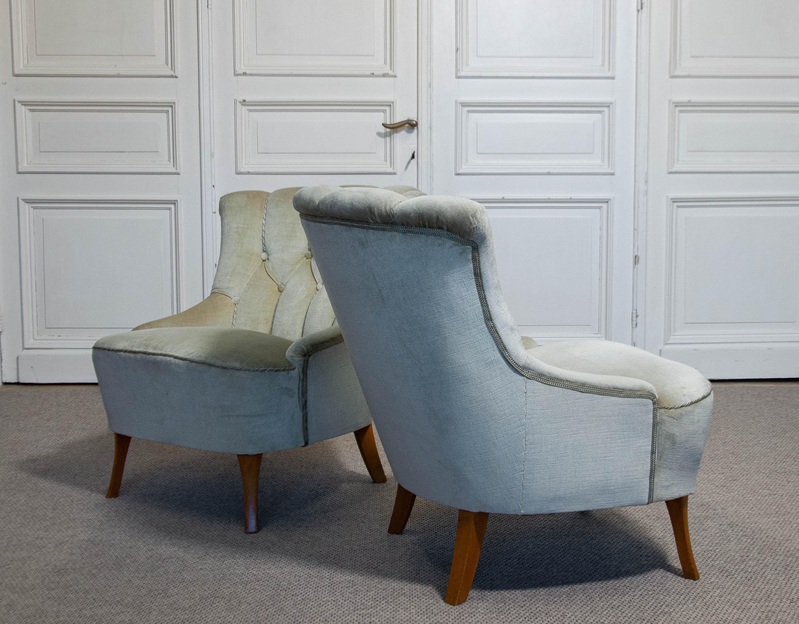 A pair of light green slipper chairs from Sweden, dating back to the 1940s. The chairs are upholstered in green velour and feature a beautifully tufted backrest. Designed for both comfort and support, they offer an elegant and timeless seating