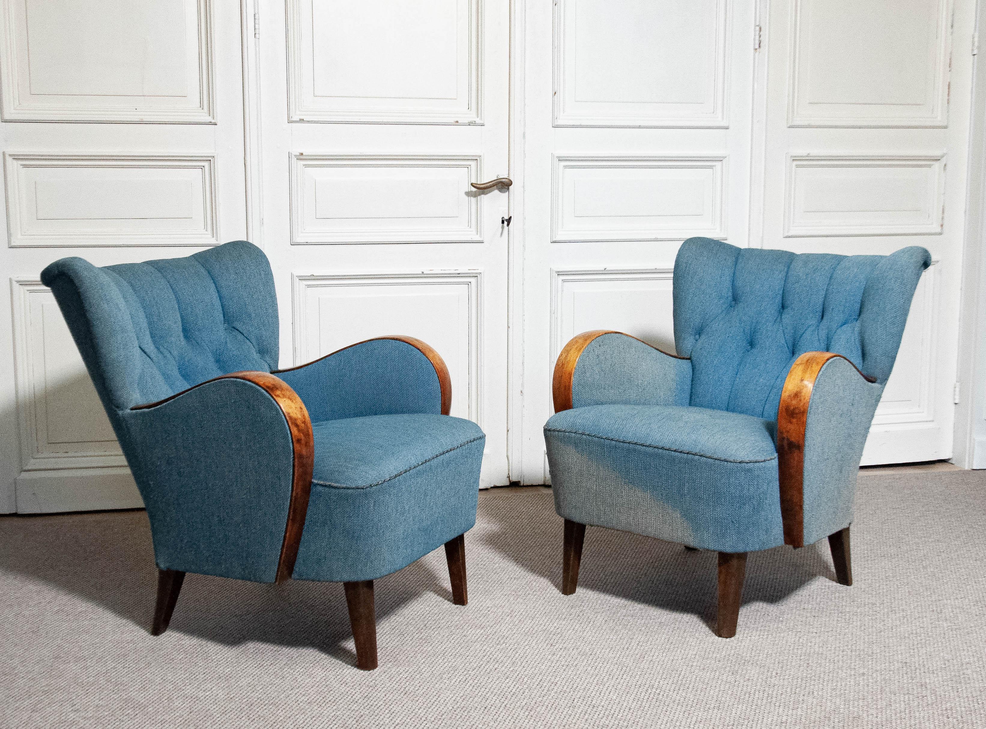 Il s'agit d'une paire de fauteuils suédois Art Nouveau des années 1940, dotés d'un dossier paddé et d'accoudoirs en bois incurvés, ajoutant un design élégant et intemporel. Les chaises offrent un confort exceptionnel et ont été nettoyées à sec, ce