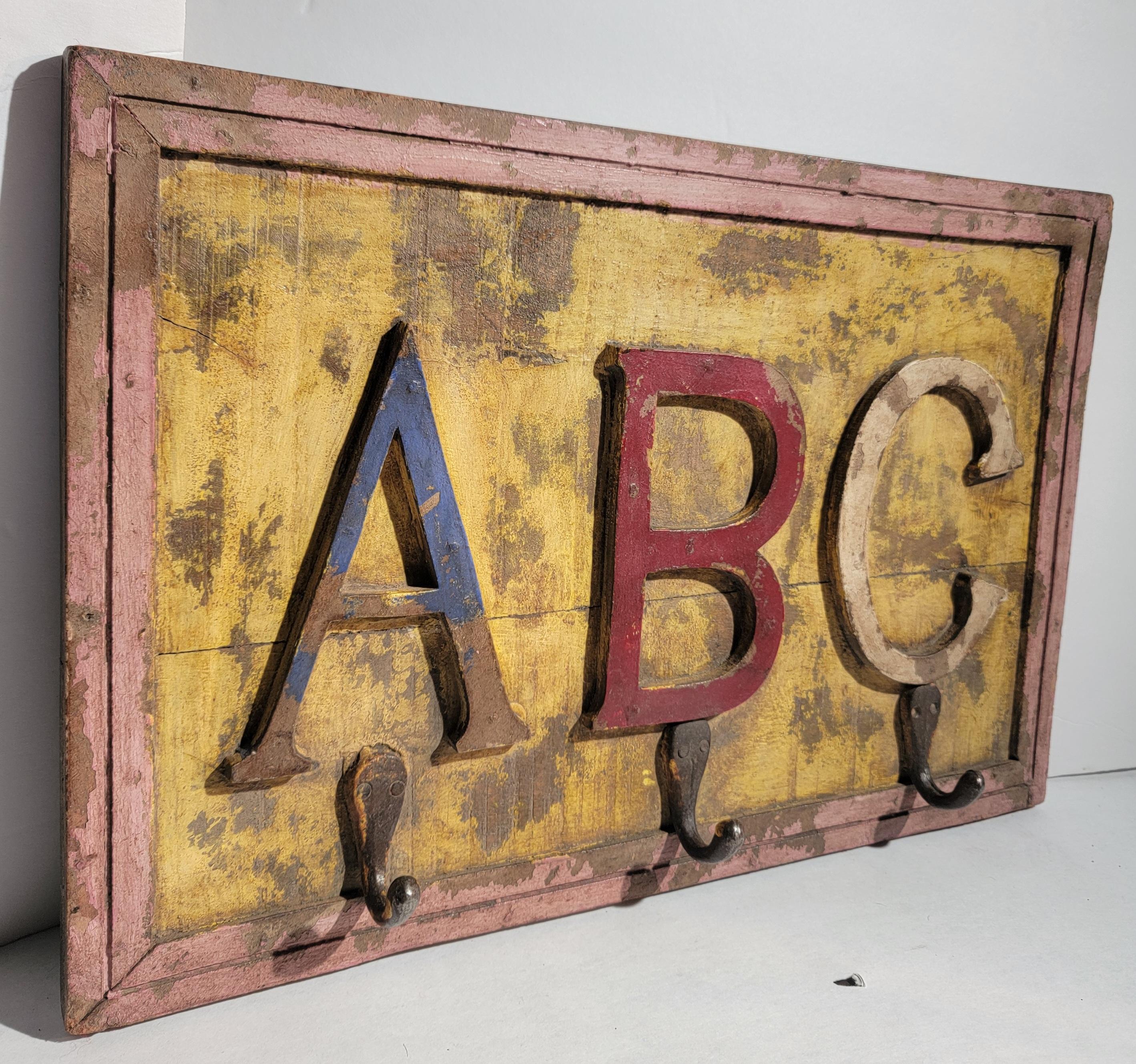 Fun and colorful wooded 40s ABC hat and coat rack. this colorful hat or coat rack has a fun childish feel that shouts wonder and imagination. Such a fun and subtle way to present the childish nature in an antique. The back of this board has 2