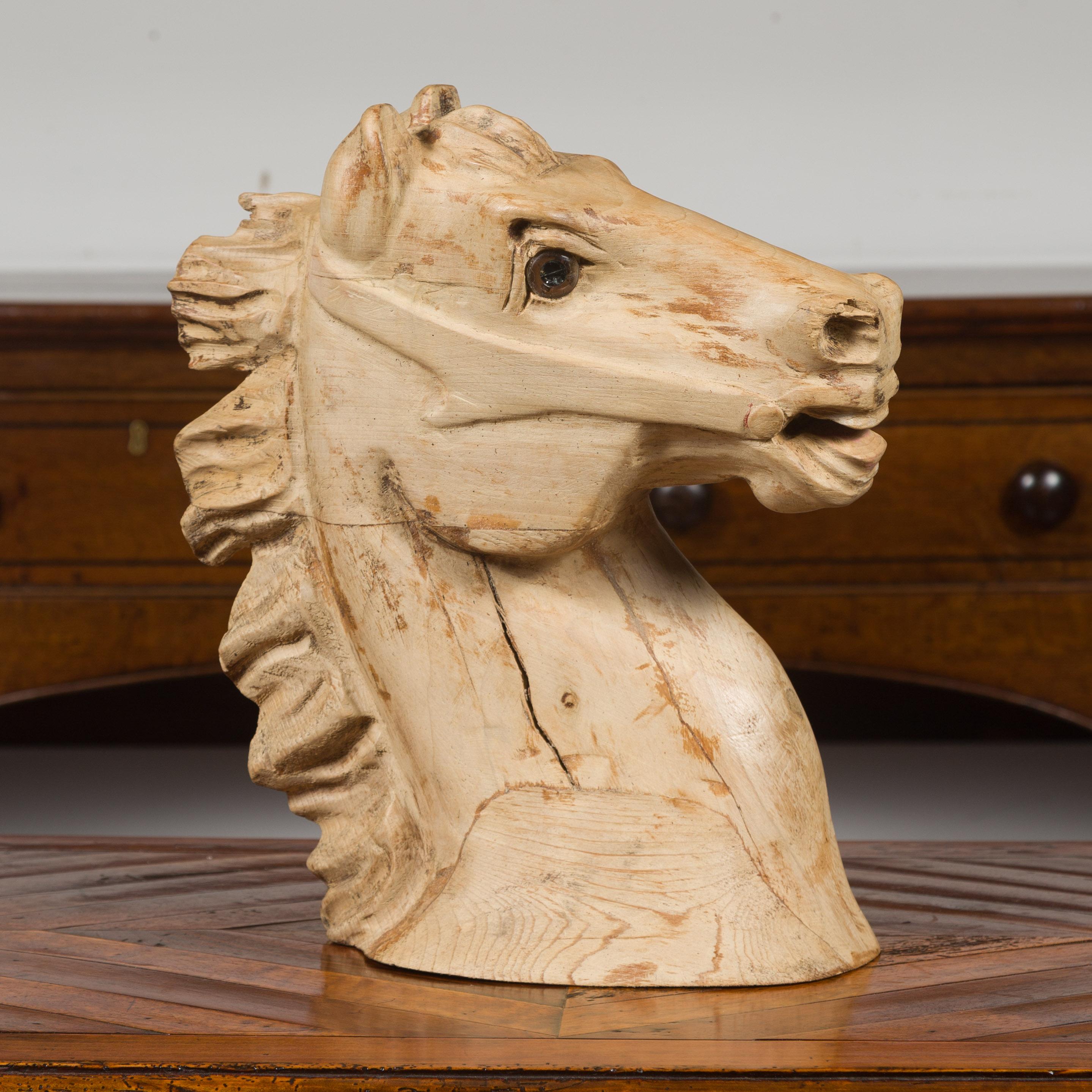Fragment de tête de cheval américain en bois sculpté, datant du milieu du 20e siècle, avec une belle patine d'usage. Fabriquée en Amérique au cours du deuxième quart du XXe siècle, cette tête en bois sculpté retient l'attention par ses traits