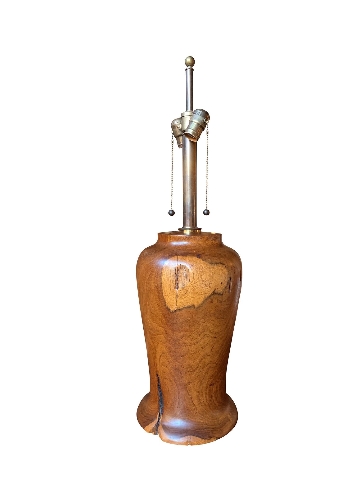 This 1940s American craftsman table lamp is hand-crafted from hardwood. The wood has a beautiful, warm patina and organic wear that adds character to the lamp. Newly rewired, the lamp has a double cluster bulb sockets with metal thread pulls. It is