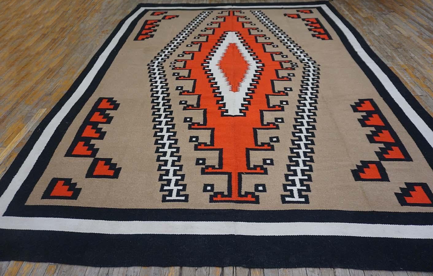 This a well-woven vintage Native American carpet in a generalized two grey hills manner with a camel-tone field and bent off white and black square toothed lines supporting a tall red stepped lozenge medallion enclosing red and off-white nested