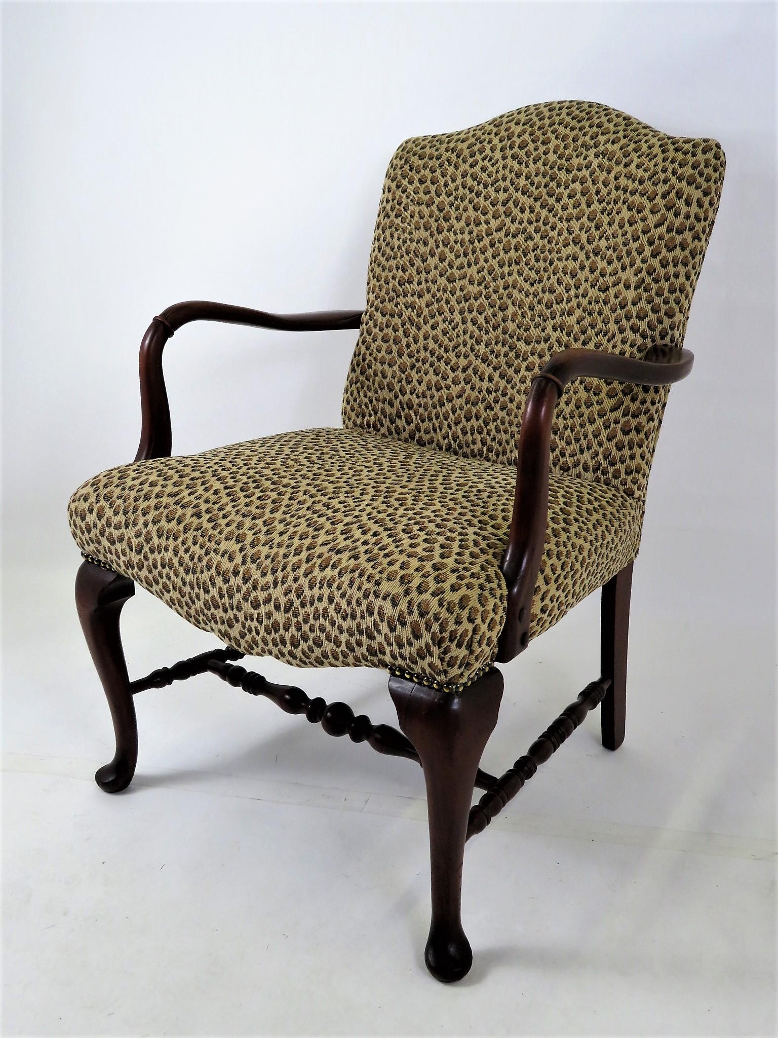 1930s-40s American Queen Anne Style upholstered armchair. Having a shaped apron of the front of the seat, turned wood stretchers, Queen Anne pad feet and a carved ring on each arm. Upholstered in a chenille leopard pattern. Original finish with