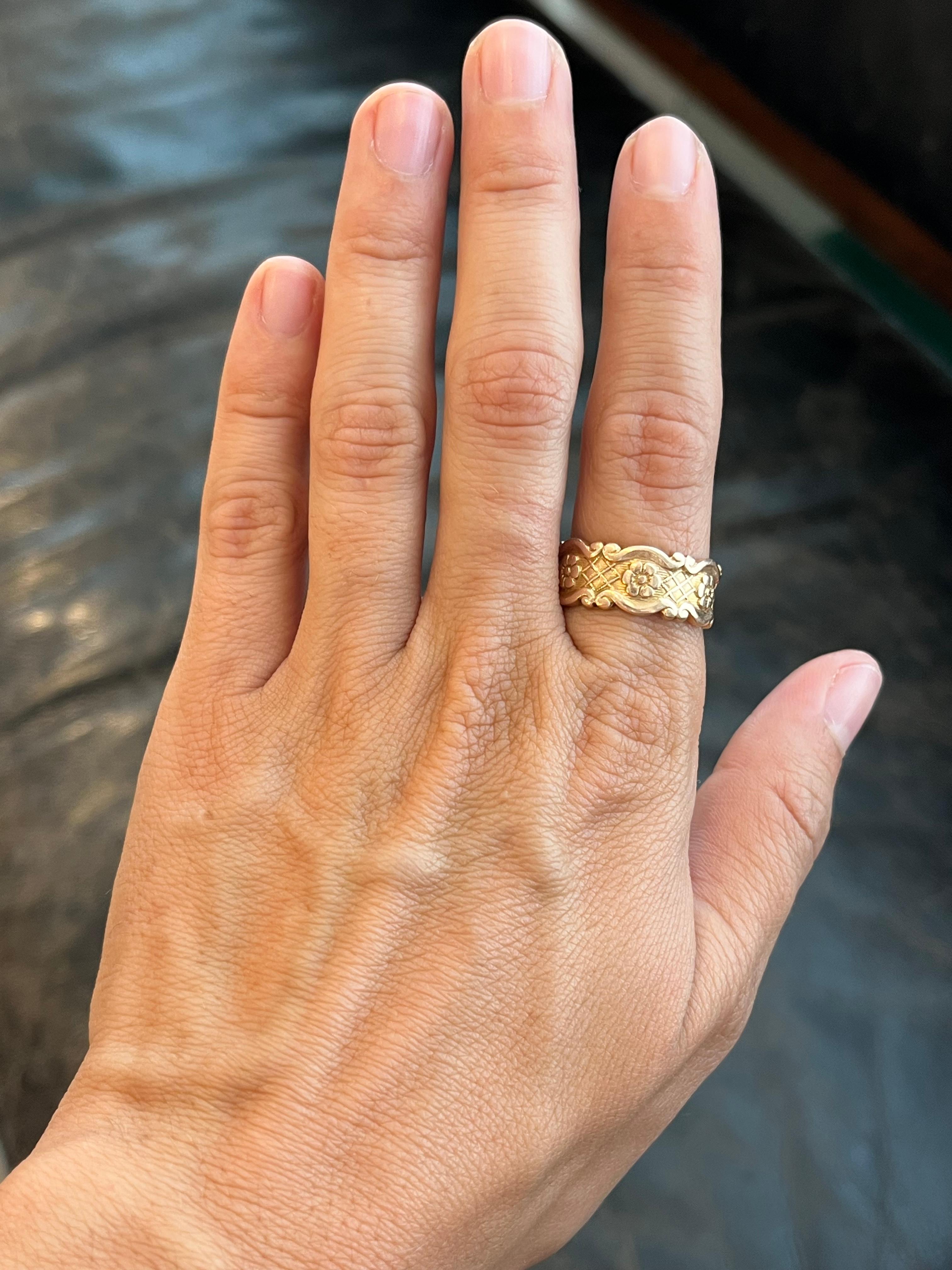 Esta alianza antigua con motivos florales en oro rosa de 14 quilates es uno de los muchos hallazgos únicos de nuestra colección de alianzas vintage en Bracken Jewelers de Santa Monica, California. Su anchura de 8,7 mm permite que se vea el precioso