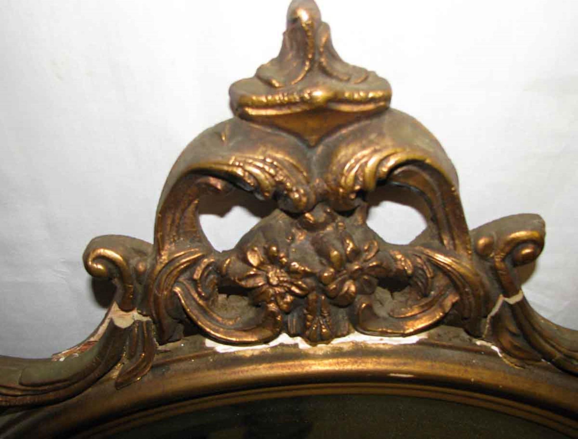 Hand carved wood frame mirror with gold gilt finish and original oval beveled mirror, circa 1940s. This can be seen at our 333 West 52nd St location in the Theater District West of Manhattan.