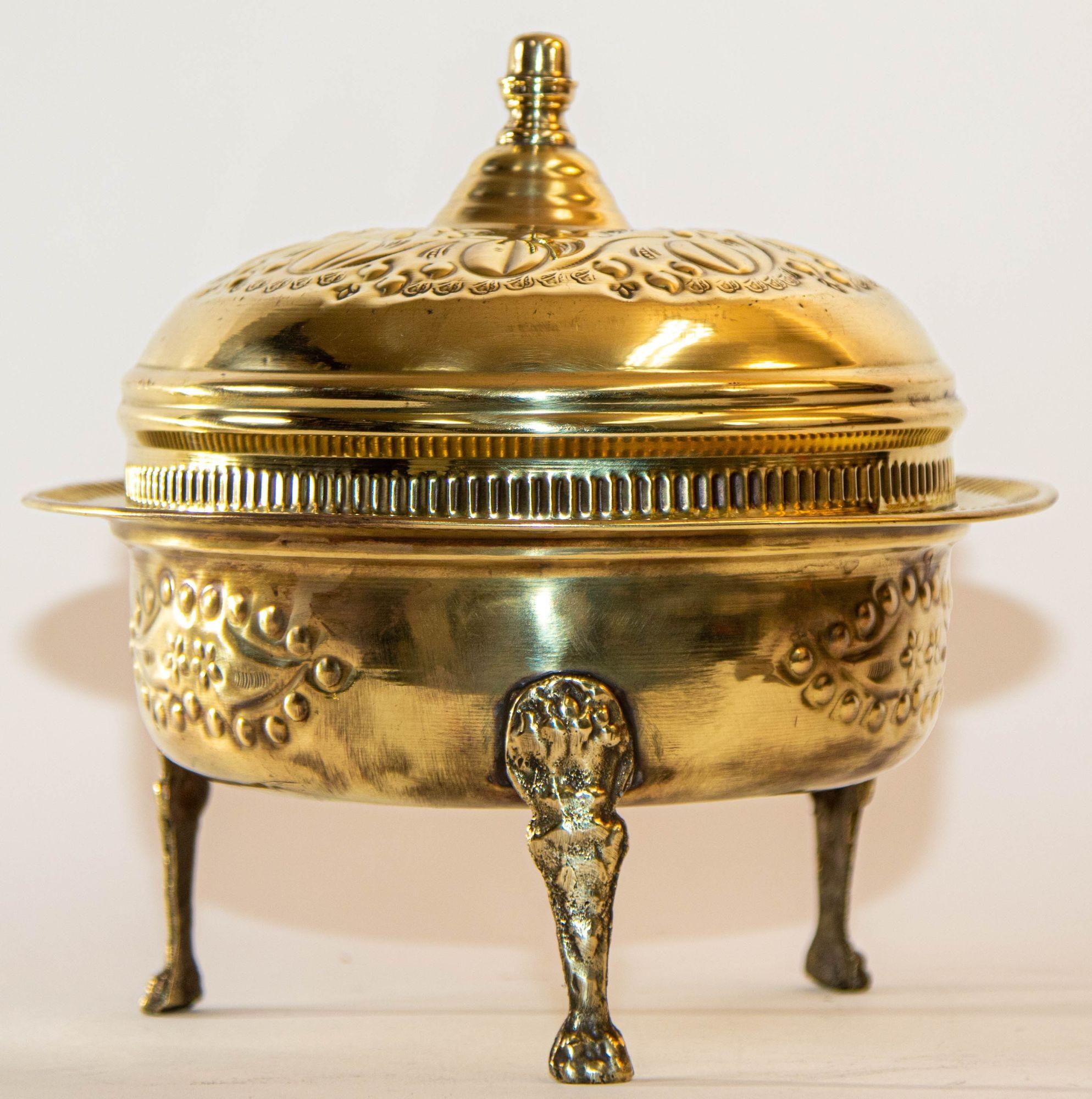 Antique round Moroccan brass dish with dome lid and paw lion feet.
Beautiful Moroccan handcrafted covered footed serving dish with embossed textured brass top and bowl.
This lovely piece features a domed lid hammered with etched engraved design and