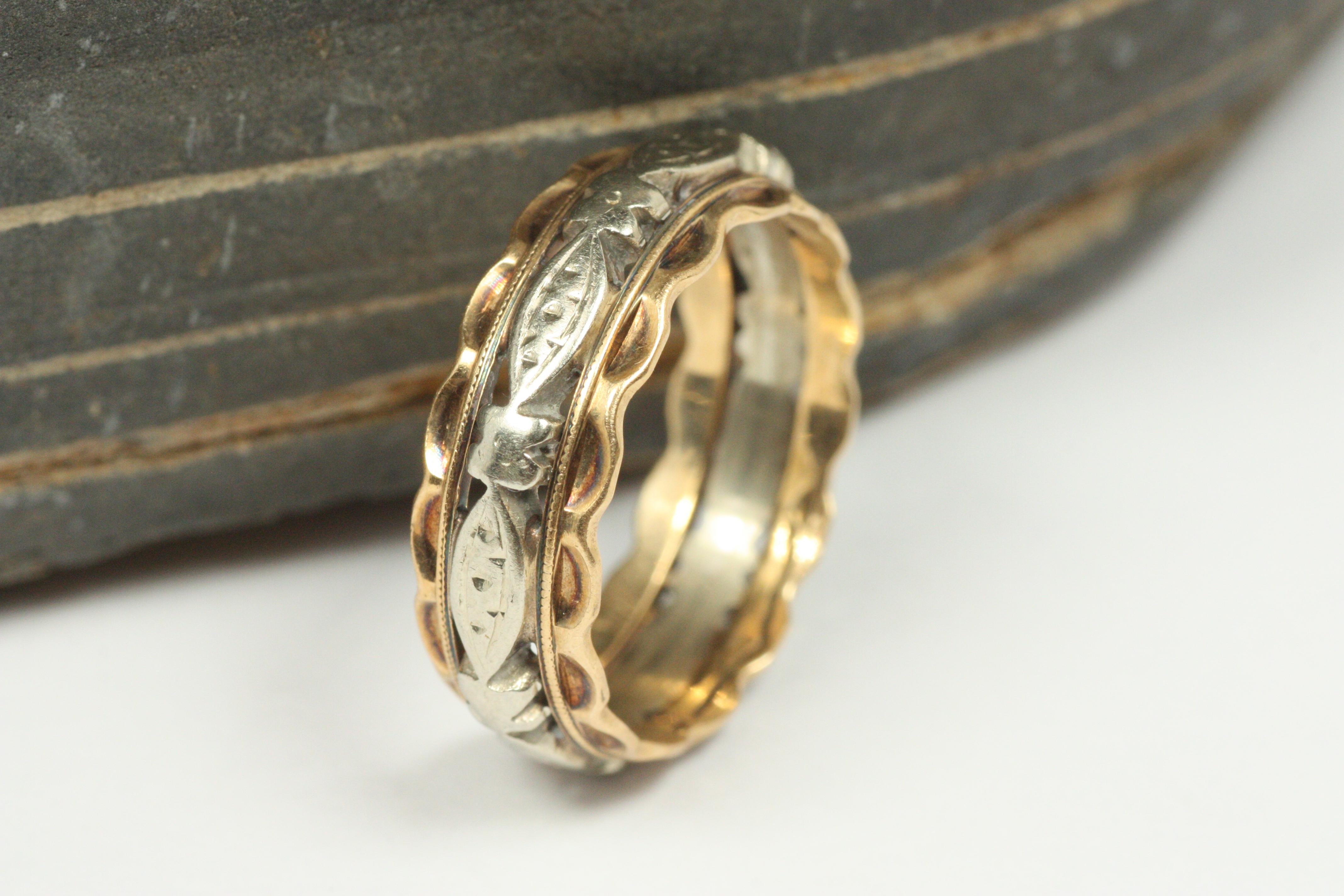 Esta antigua alianza bicolor de oro de 14 quilates de la década de 1940 es uno de los muchos hallazgos únicos de nuestra colección de alianzas vintage en Bracken Jewelers de Santa Monica, California. Presenta un centro con motivo marquesa de oro