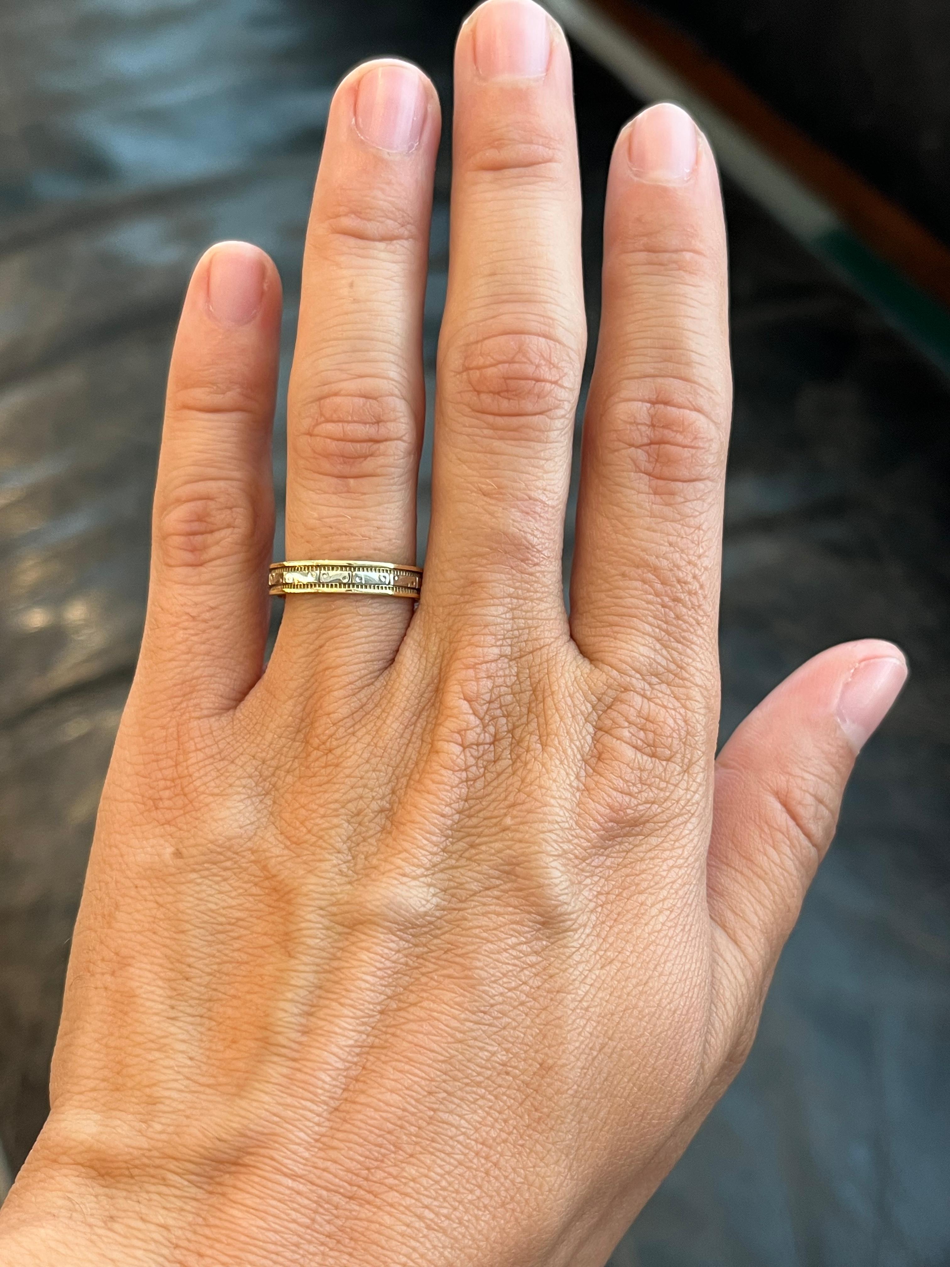 Esta alianza vintage de oro amarillo y blanco de 14 quilates en dos tonos con un diseño facetado y grabado es uno de los muchos hallazgos únicos de nuestra colección de alianzas de boda en Bracken Jewelers de Santa Monica, California. En el centro