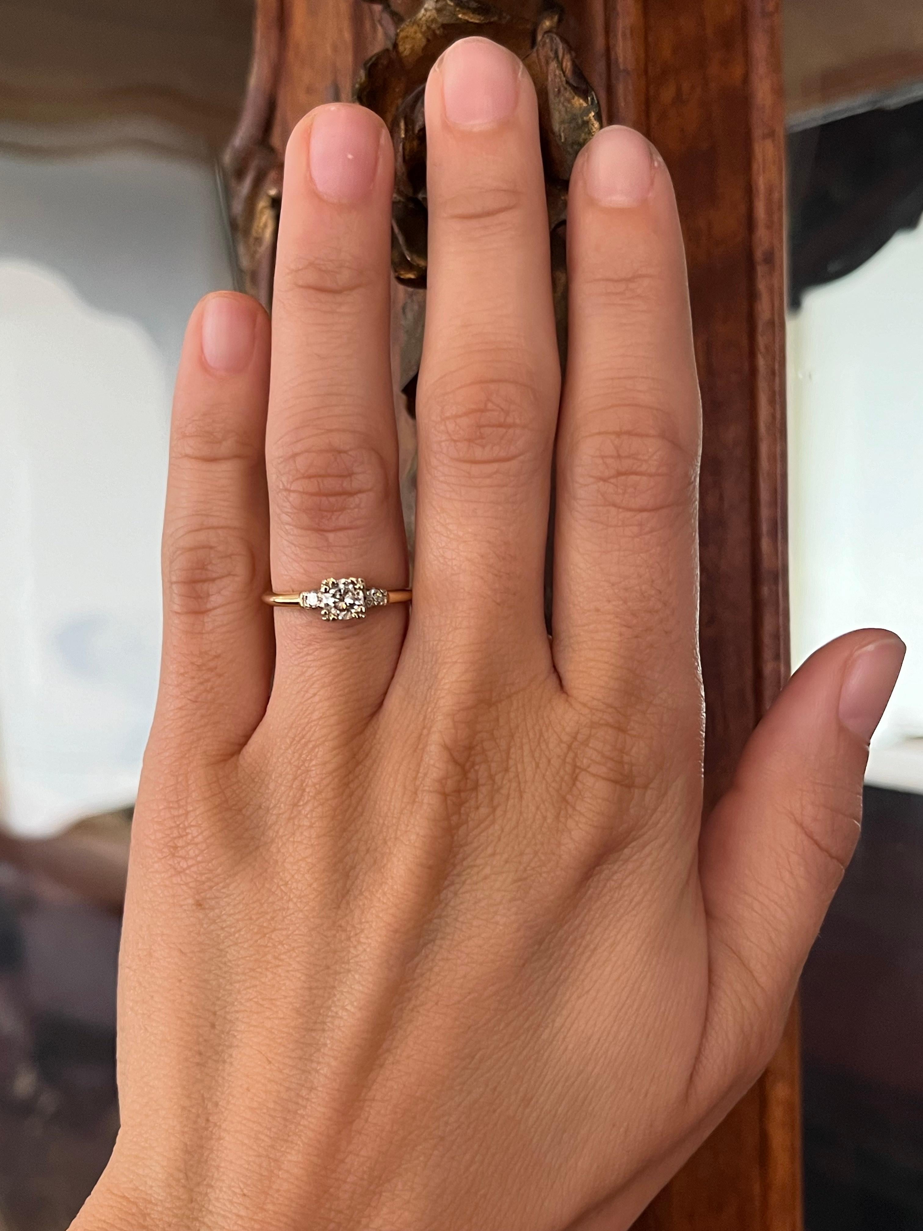 Clin d'œil romantique au passé, cette bague de fiançailles à trois pierres est centrée sur un diamant taille ancienne de 0,48ct (VS2, J), accentué par 0,30cttw de pierres latérales rondes taillées en brillant. Réalisée en platine avec des