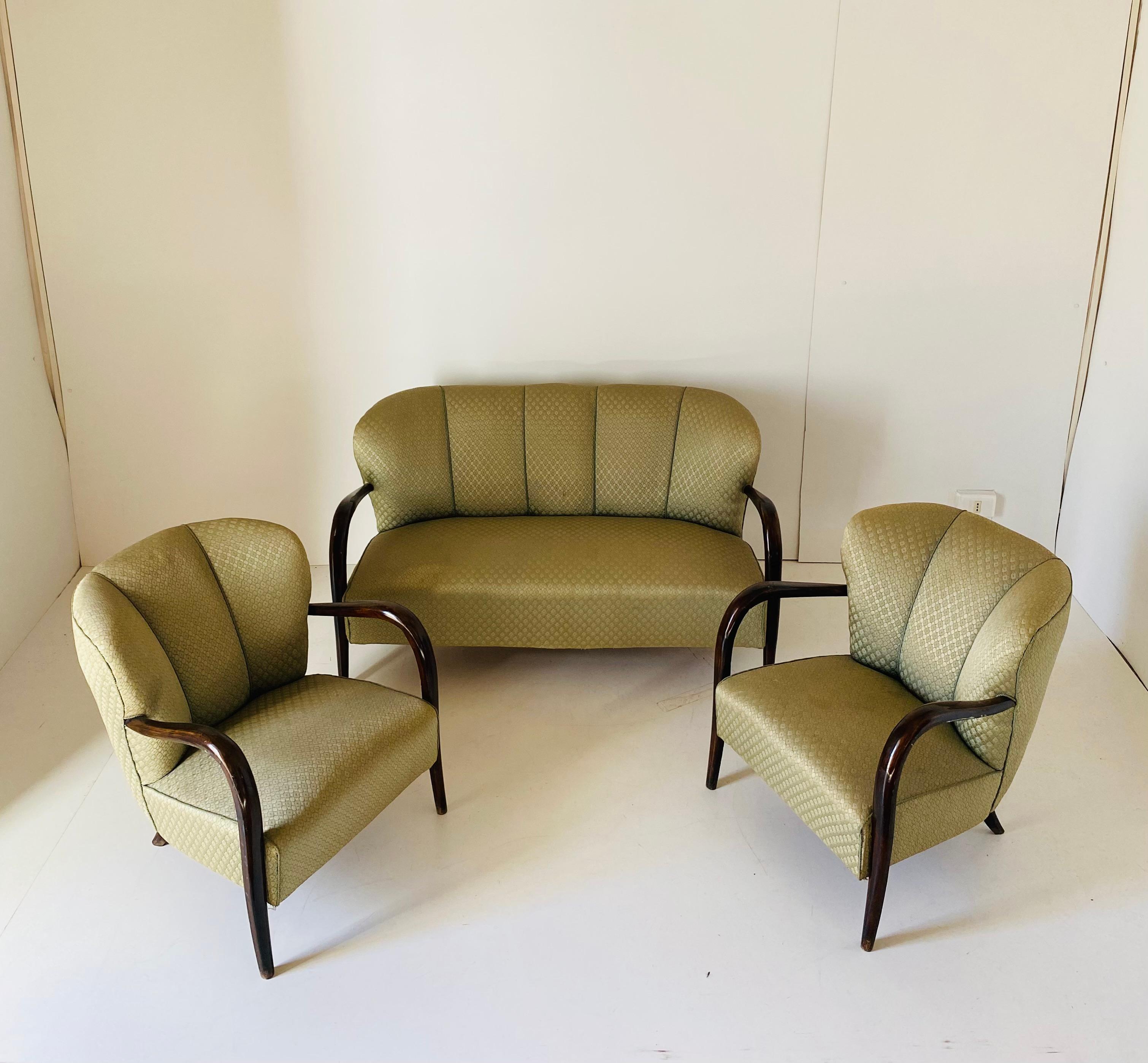 Ein seltenes Art-Déco-Wohnzimmer-Set aus den 1940er Jahren. Die in Frankreich gefertigte Garnitur besteht aus zwei Sesseln und einem Zweisitzer-Sofa. Beide Sessel und das Sofa haben noch ihren Originalstoff, der sich seinem Alter entsprechend in