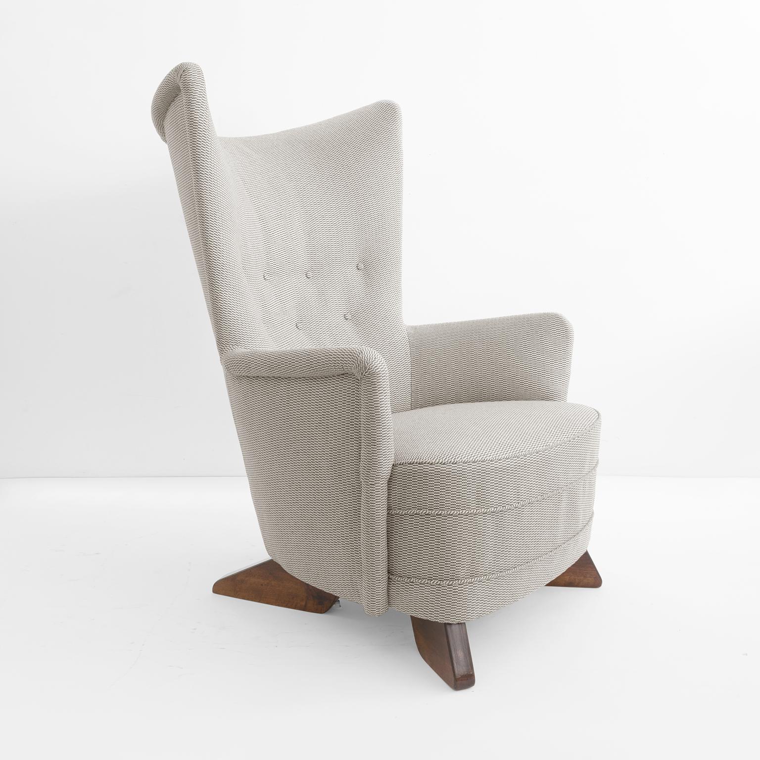 Finnish interior architect, Carl Gustaf Hiort Af Ornäs designed modernist 1940s armchair with a high rounded back, detailed with a rolled edge. Four solid stained wood wedge shaped legs provided a sculpture like base to the chair.  Produced at Hiort