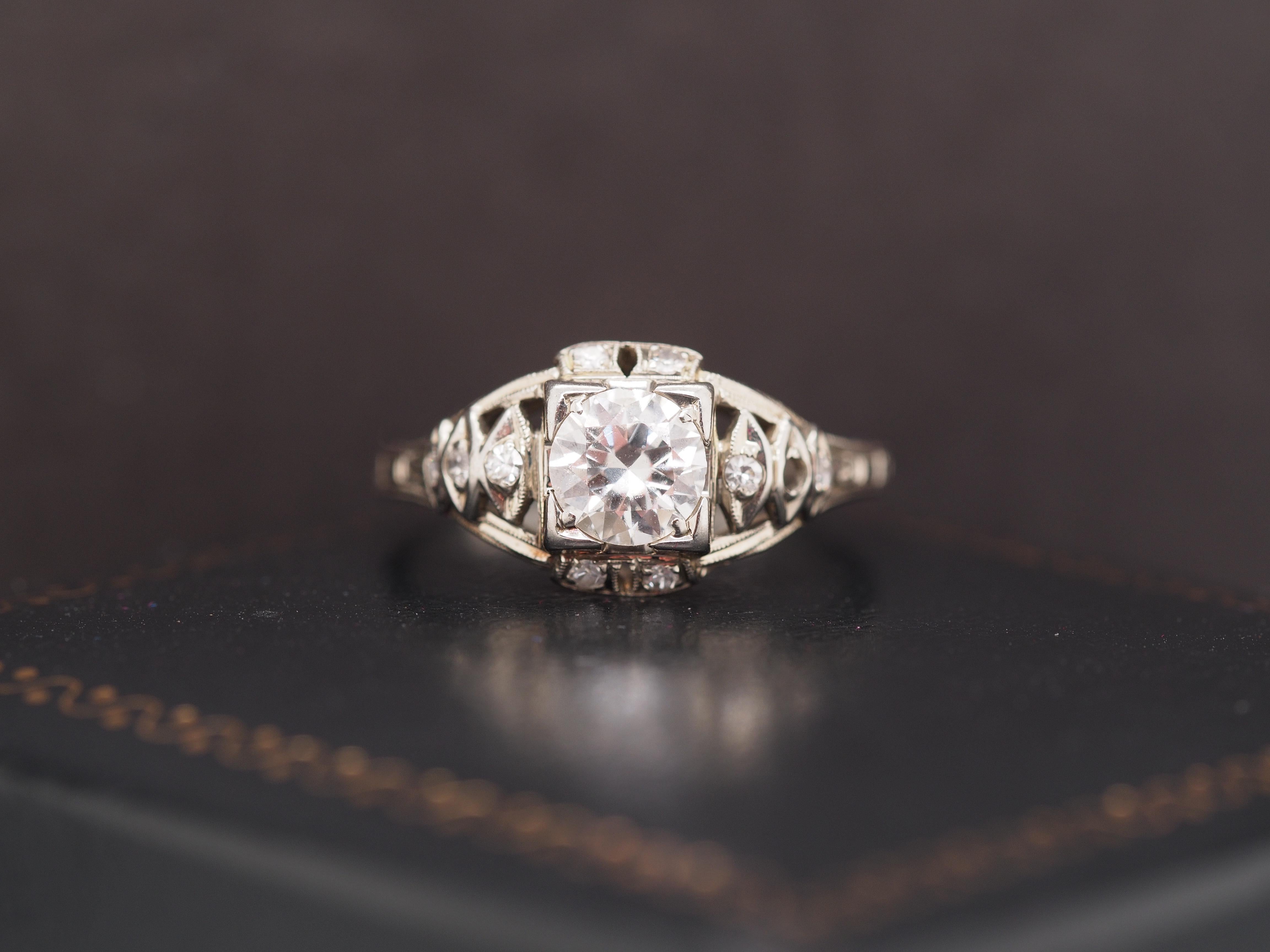 Año: 1940
Detalles del artículo:
Tamaño del anillo: 5
Tipo de metal: Oro blanco de 18 quilates [Hallmarked, and Tested].
Peso: 2.0 gramos
Detalles del diamante: Diamante Natural, .60ct, Redondo de Transición, Color F, Claridad VS.
Ancho de banda:
