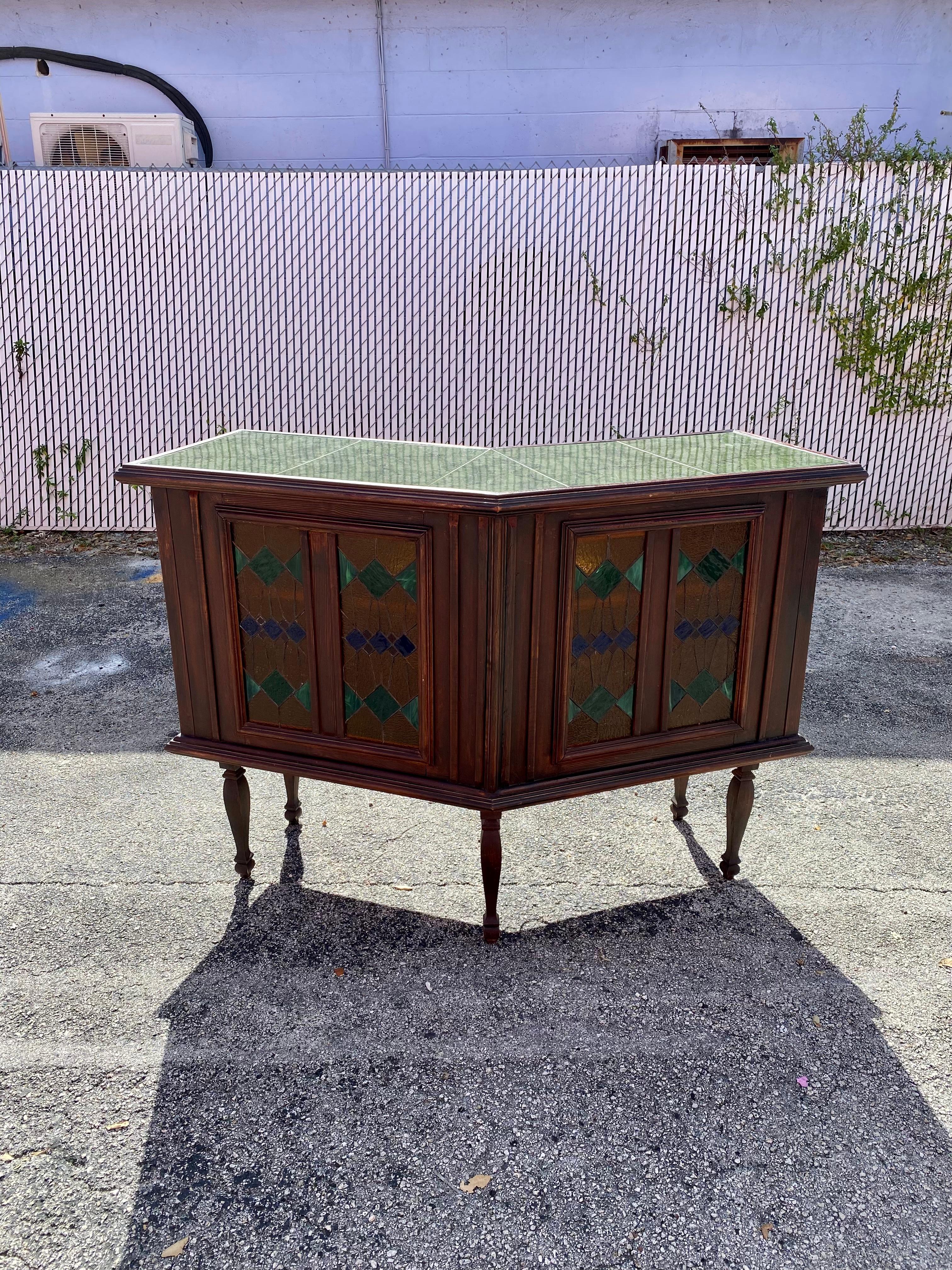 On offer on this occasion is one of the most stunning, Art Deco bar cabinet or versatile table you could hope to find. Outstanding design is exhibited throughout. Just look at the gorgeous details on this beauty! Faux marble tile top. Stained glass