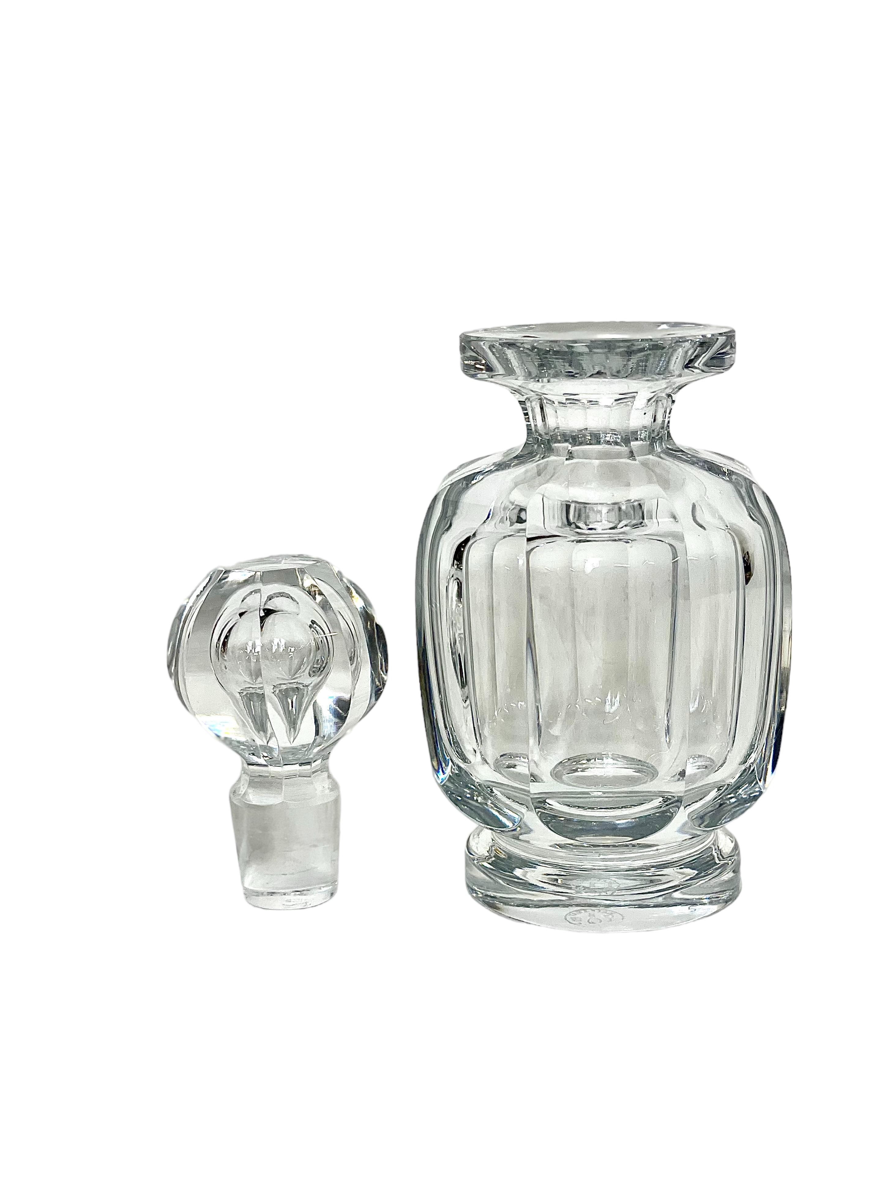 Un magnifique flacon en cristal Baccarat Art déco des années 1940, avec un bouchon octogonal à multiples facettes, conçu à l'origine pour orner une élégante table de toilette du milieu du siècle dernier. D'une hauteur d'un peu plus de 15 cm, cette