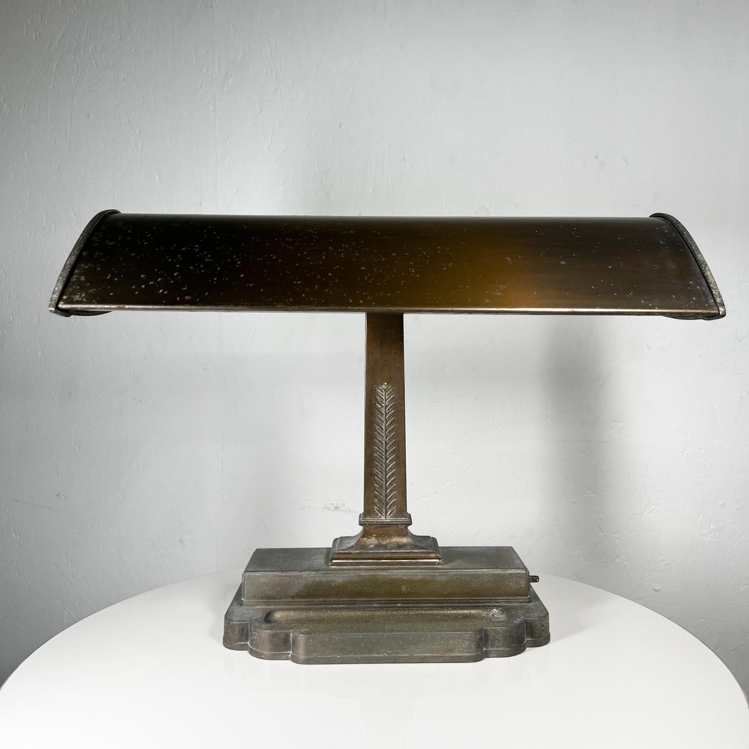 Early modernist Art Deco or Machine Age desk lamp by Globe Specialty Co. circa 1940s.
Art deco banker lamp with original glass diffuser.
Label has worn off. 
Globe Specialty Co. Chicago.
Push button switch on metal base.
Measures: 21 wide x 9