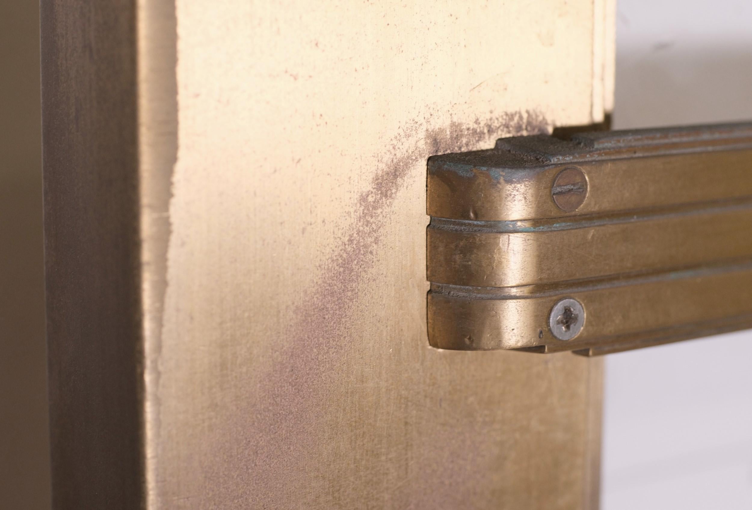 Pair of Art Deco bronze entry doors with single vertical glass lites each. These 1940's commercial doors come with the original door pulls and push bars which are intact. The push bars feature straight lines with an Art Deco design. Glass broken in