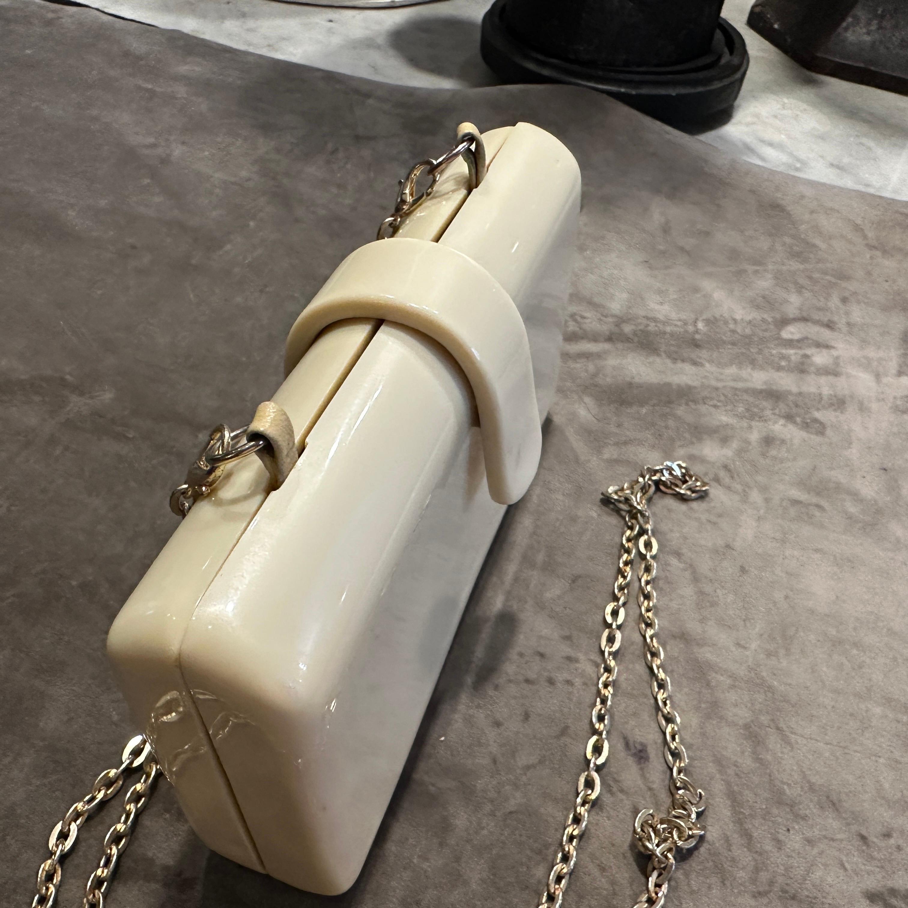 A rare gem from the 1940s, this Italian Art Deco shoulder bag is crafted from luminous cream Bakelite with a sleek, structured silhouette. Its minimalist form is elevated by elegant details, including a gracefully curved front tab closure and a luxe