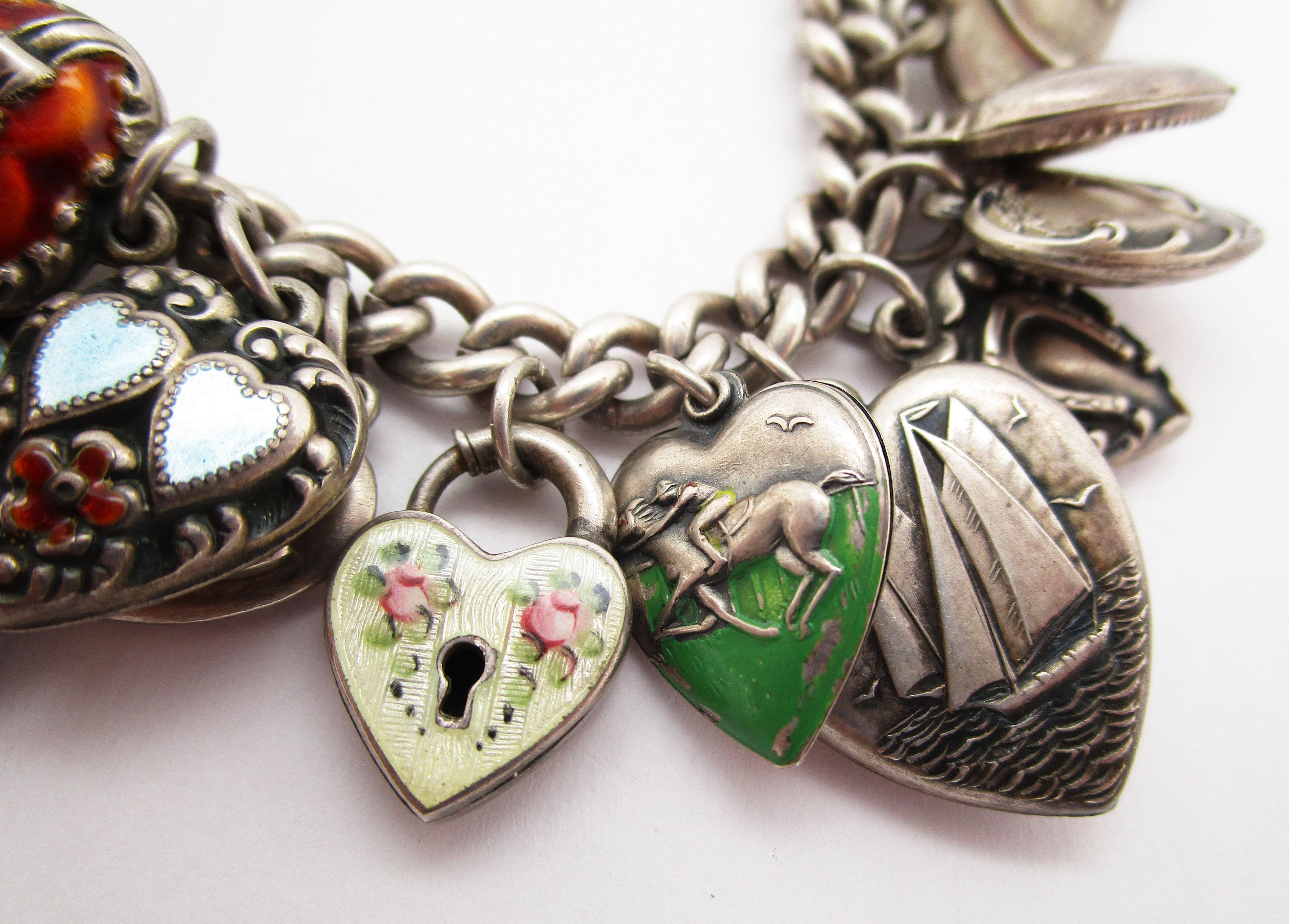 This is a gorgeous Art Deco charm bracelet in sterling silver with dozens of beautiful enameled love heart charms! In a definitive WWII look, this bracelet incorporates hearts, aviators, cornucopias, florals, sailboats, and horses on hearts. It is