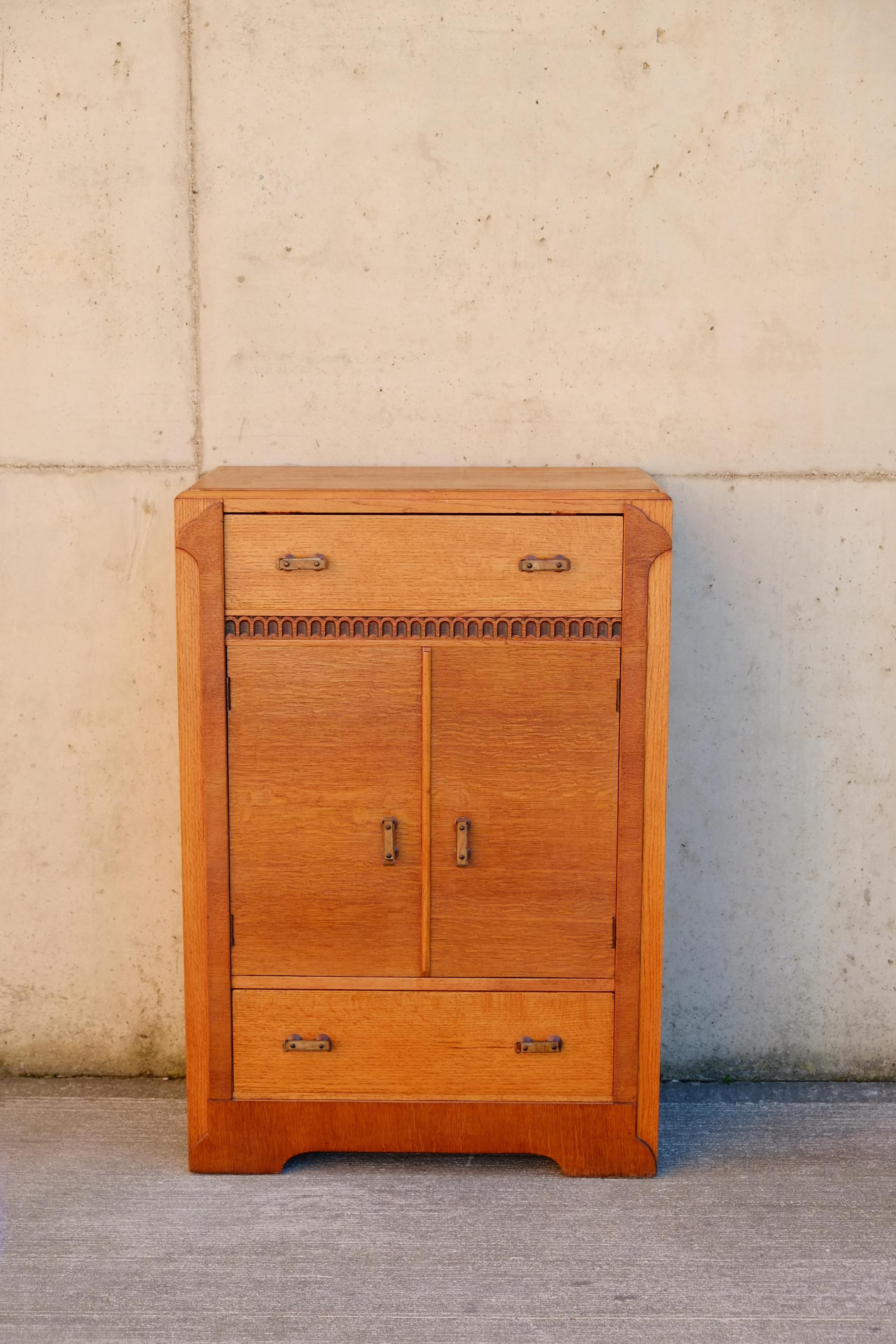 Tallboy anglais Art déco des années 1940. Il s'agit d'un beau grand garçon en chêne avec de jolis détails décoratifs dans des tons contrastés de chêne. Le buffet est fabriqué en contreplaqué léger avec de magnifiques placages de chêne chaud. Le
