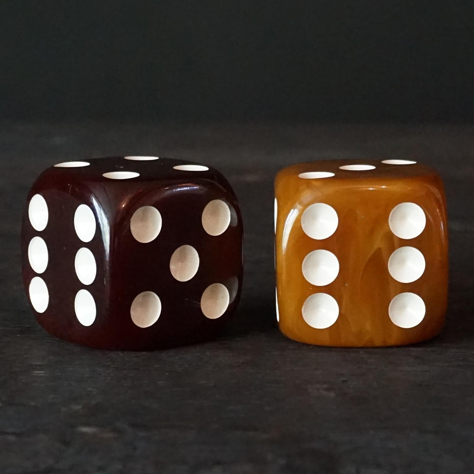 Very pretty set of two large and heavy oversized jumbo bakelite dice in luscious dark butterscotch and delicious caramel swirl colour. 
Art Deco at its best in design and colour, these are must have for a collector and they are not easy to find in