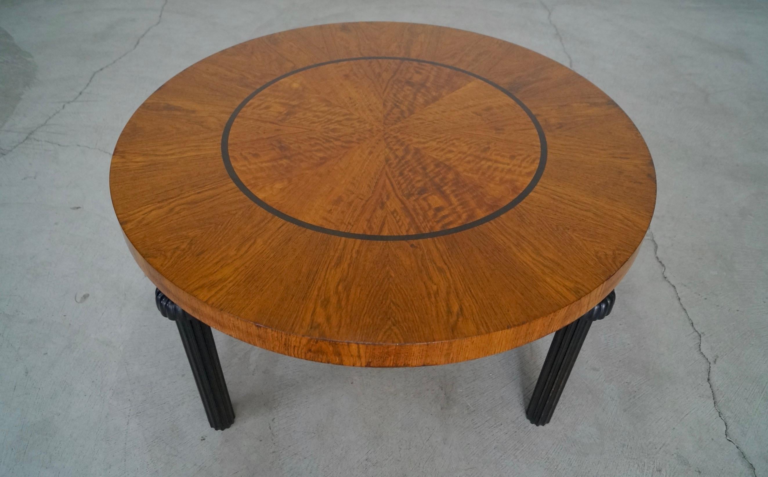 Vintage 1940's original Art Deco coffee table for sale. Beautiful design and style and textured legs. The top has wonderful wood work with a pattern and a circle inlay. It has a walnut finish with black finished legs. It's in good vintage condition