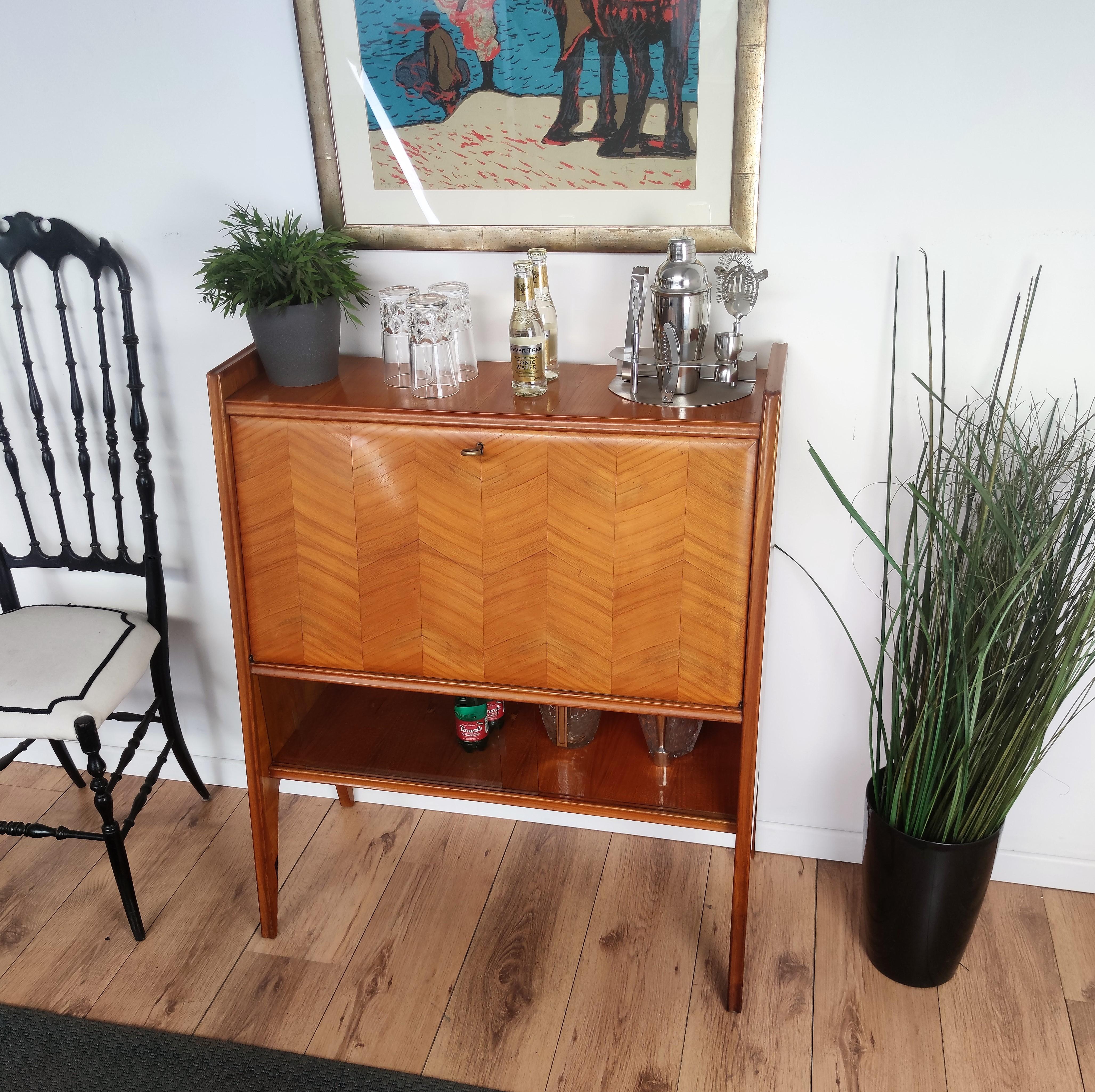 Very elegant Italian Art Deco Mid-Century Modern dry bar cabinet, in beautiful veneer walnut briar burl wood, two bottom glass doors and central flip door with amazing interior part in mirrors mosaic and antique brass keylock. The unique and typical
