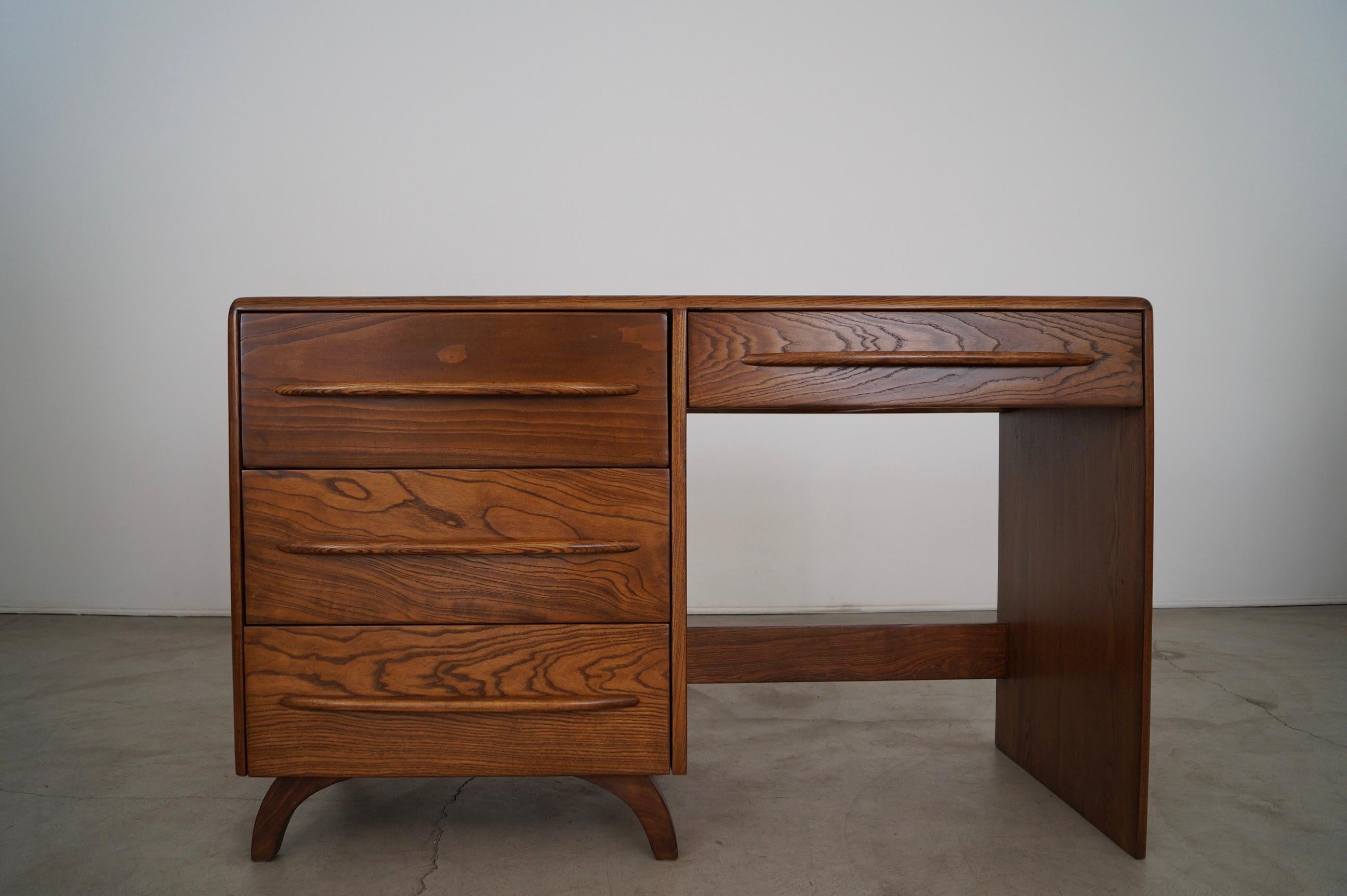Vintage Mid-century Modern desk for sale. It was manufactured by Pierce and Sons in the 1940's, and is an original piece of Art Deco Modern design. It's made of solid ash, and has been professionally refinished in walnut. It has four total drawers