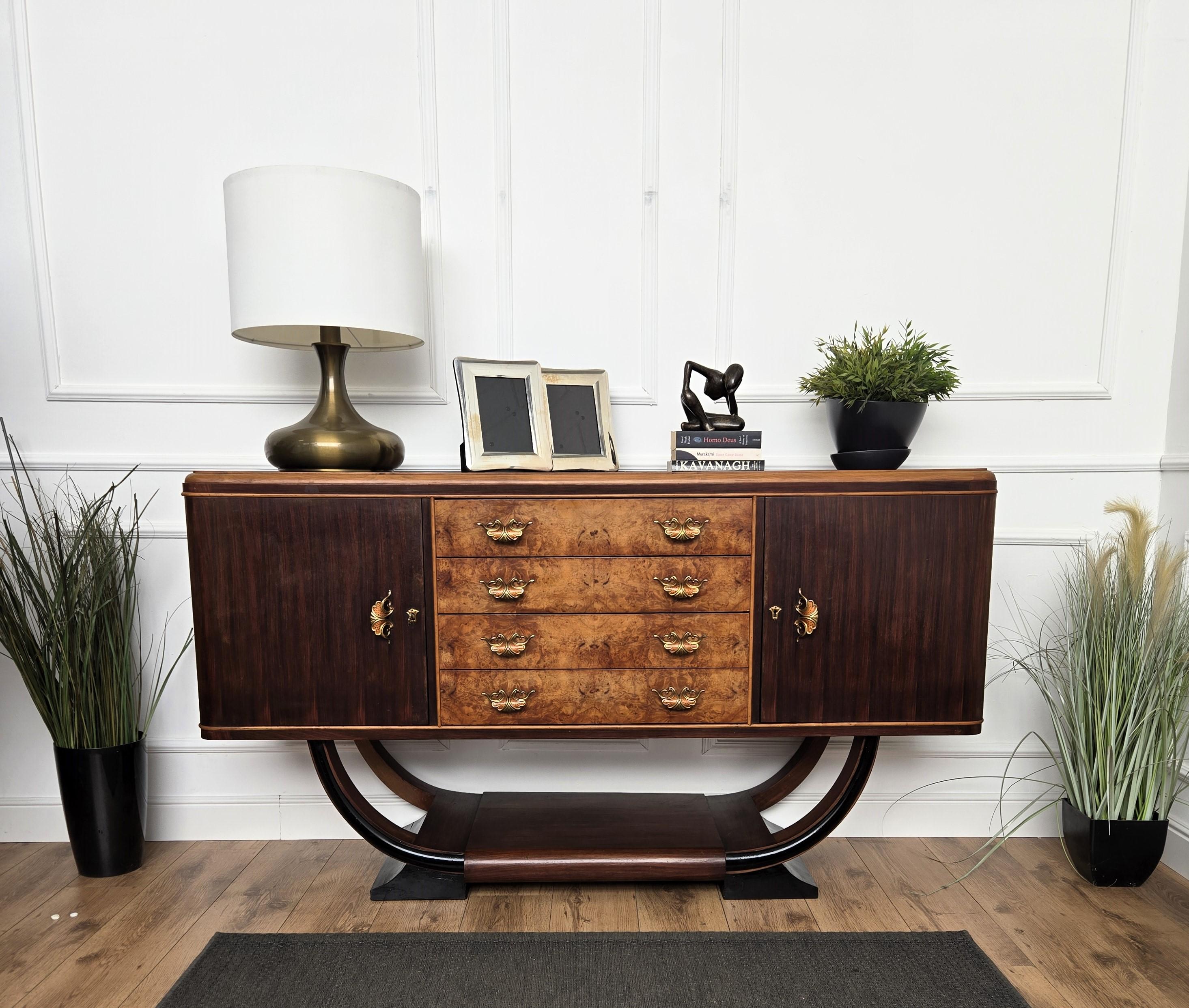 Unique and very elegant Italian Art Deco Mid-Century Modern sideboard credenza cabinet, in beautiful veneer walnut wood, with two side doors, central drawers and antique brass handles and lock. The unique and typical design and shapes make this a