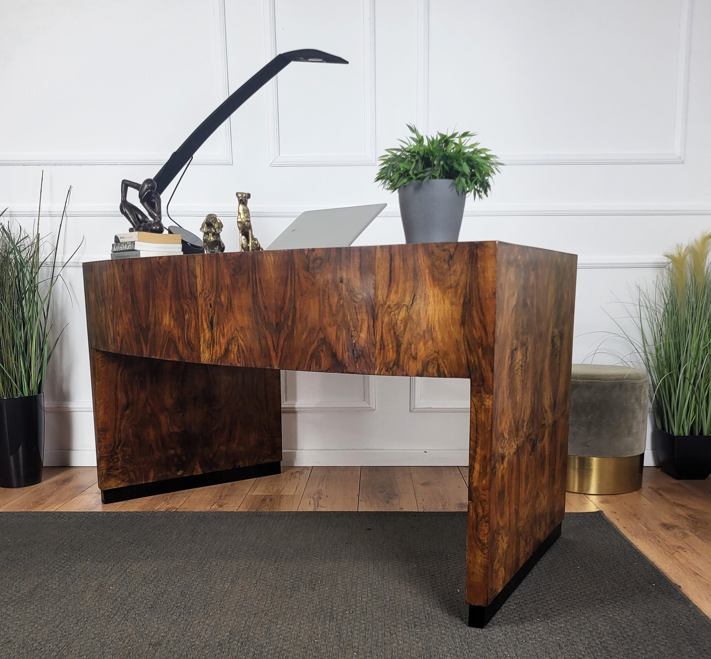 Stunning Italian Art Deco Mid-Century Modern desk writing table, in beautiful veneer burr walnut wood with beautiful and elegant curved shape, completed by the side and central drawers with brass handle. The unique and typical design, with the clean