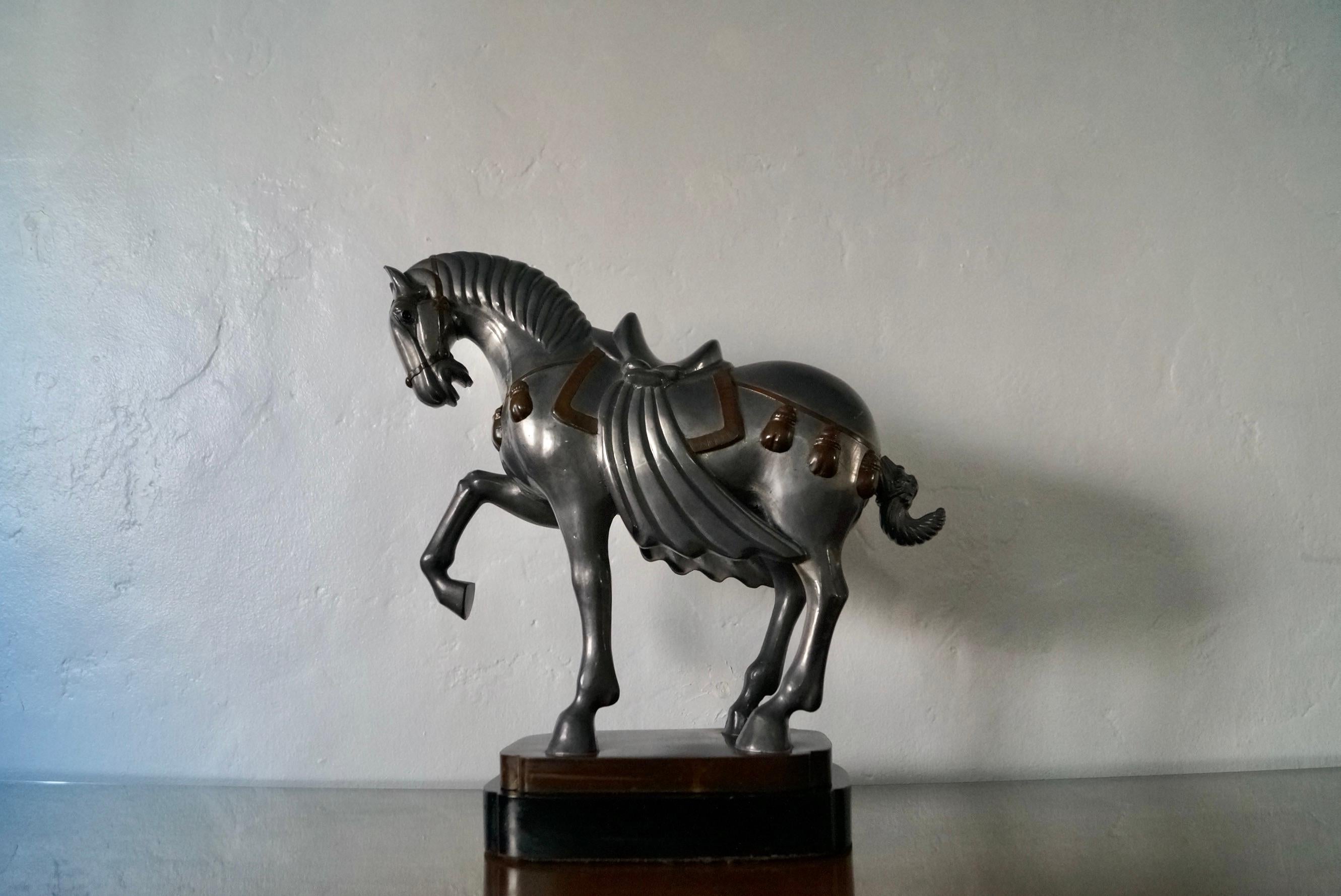 Antique horse statue for sale. Made of pewter and solid brass, and has a solid wood base. It’s really heavy and well made, and a beautiful decorative object. The pewter color and brass accents goes nicely. The horse is in a regal pose. Great