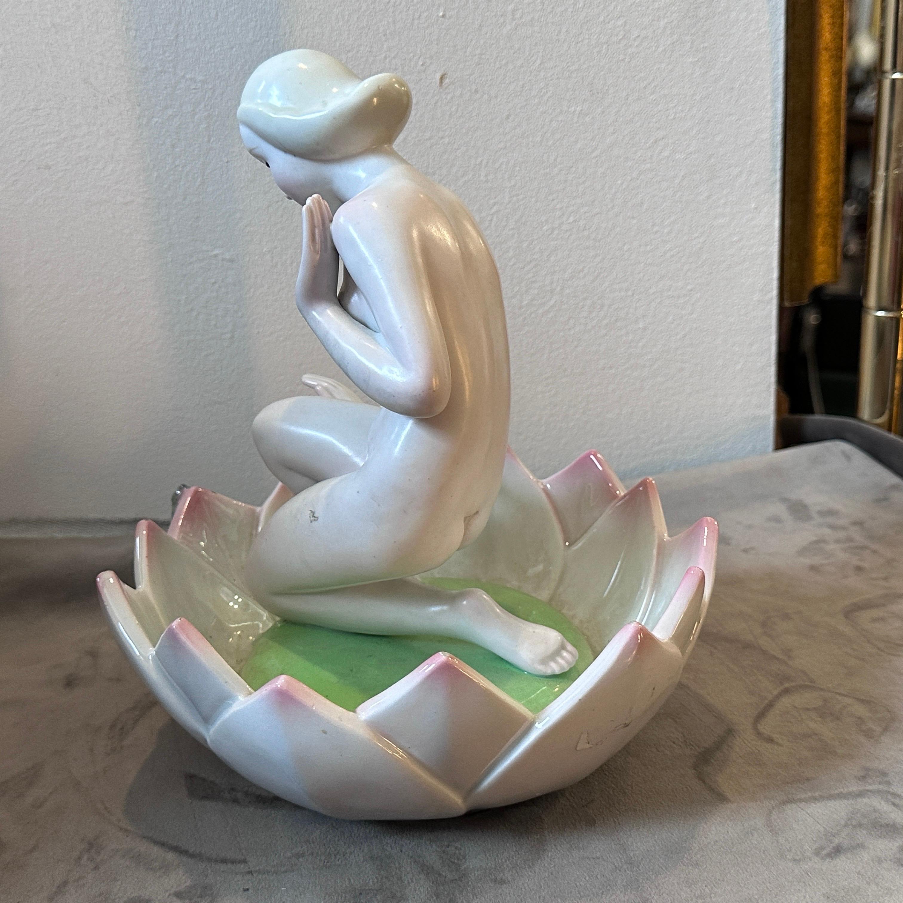 Figure en porcelaine au centre d'une fleur d'une jeune fille émerveillée à la vue d'une petite grenouille, intitulée 