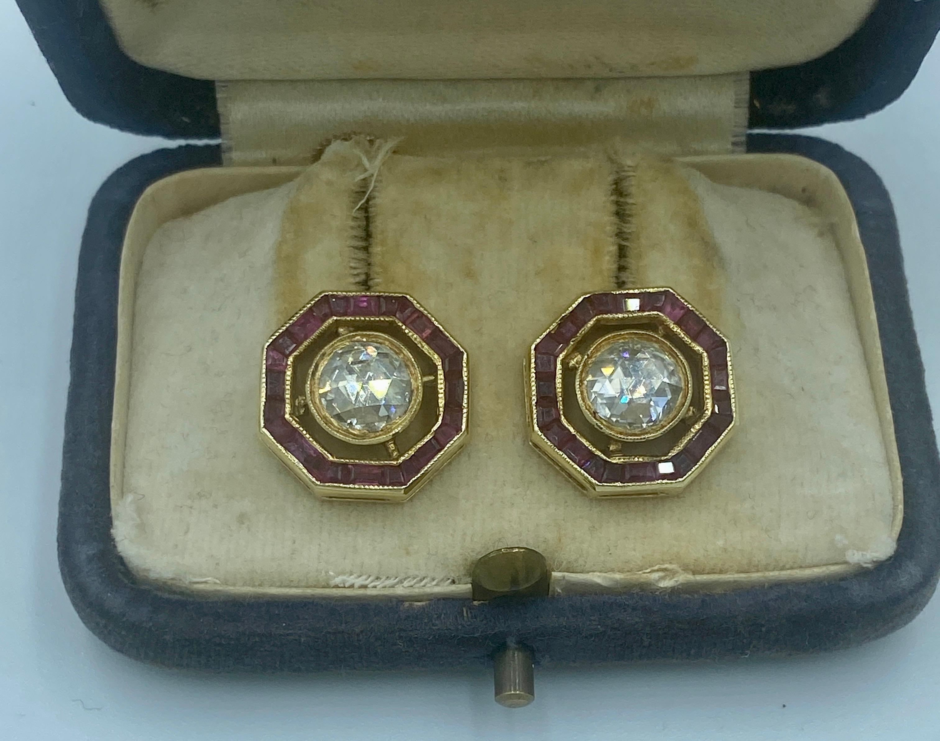 These 1940s Art Deco studs are centered around 2 beautiful rose cut diamonds of approximately 0.75 carats each. The studs are adorned with a hexagonal frame of rubies. 
