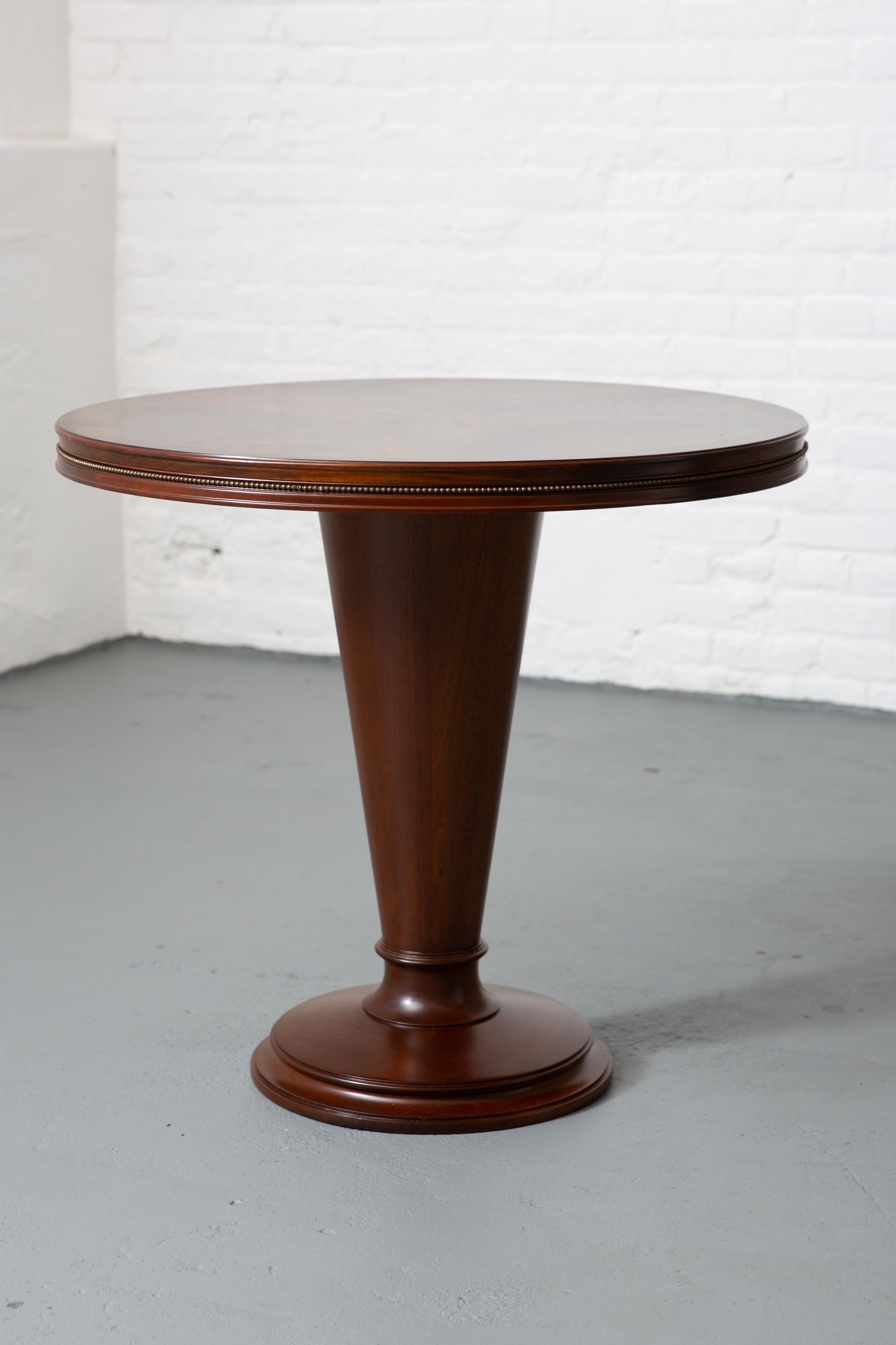 Beautiful round 1940's Art Deco center table with slim gold edging to top. Book matched flame top. Rosewood outer band. Tapered with circular multi-level mahogany base. Fine inlay detail to top.