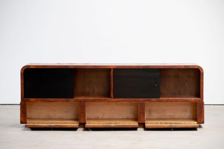 Phenomenal Art Deco sideboard or buffet from the period around 1925 in France. Amazing burr walnut on the front and black glasses gives this fantastic designed Art Deco buffet an absolute great appearance. 
 