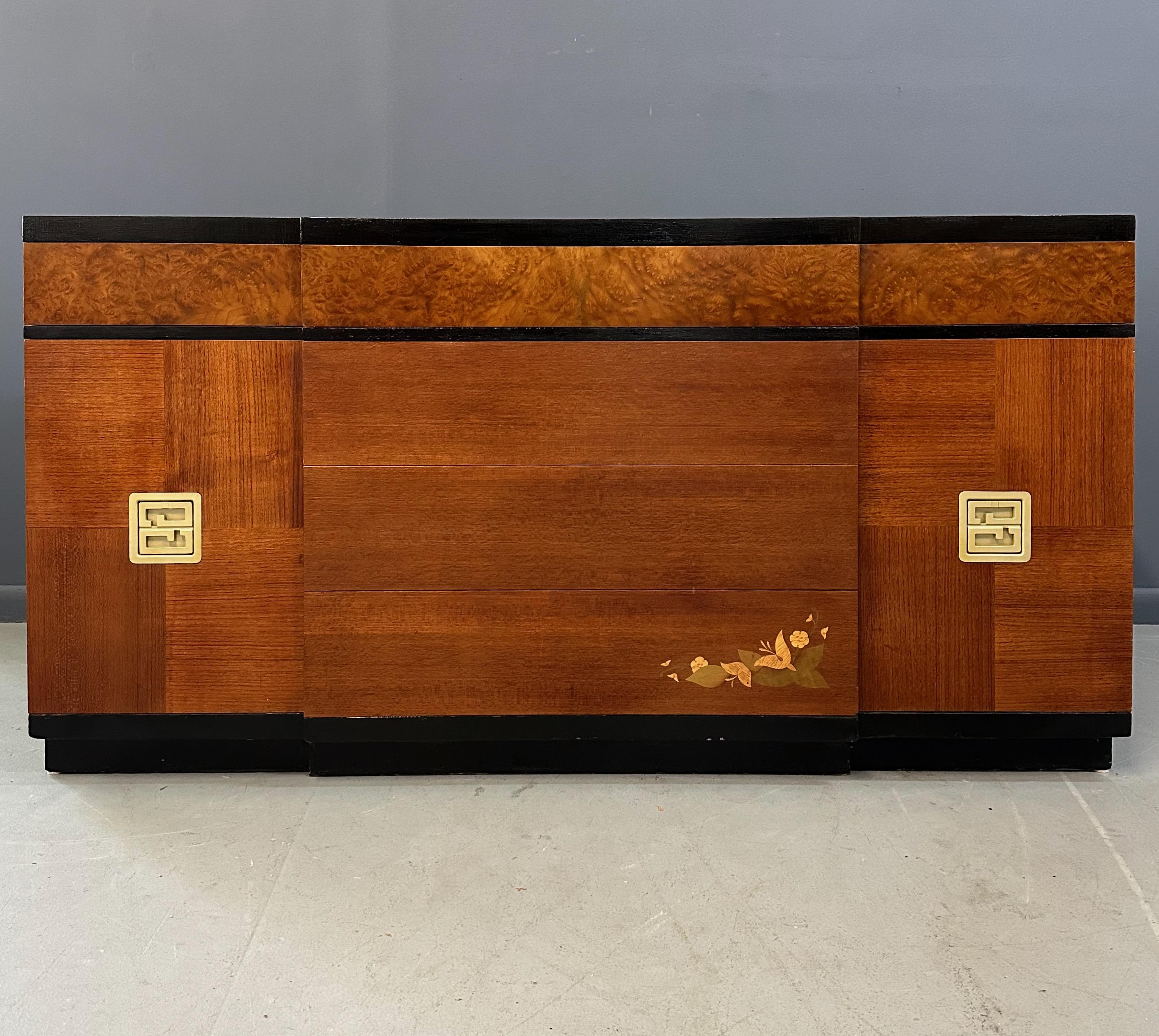 Questo squisito server in noce Vanleigh degli anni '40 presenta bellissimi fiori intarsiati e accenti di radica. Realizzato con precisione, questo server aggiunge un tocco di eleganza a qualsiasi spazio da pranzo. Il suo design senza tempo e i