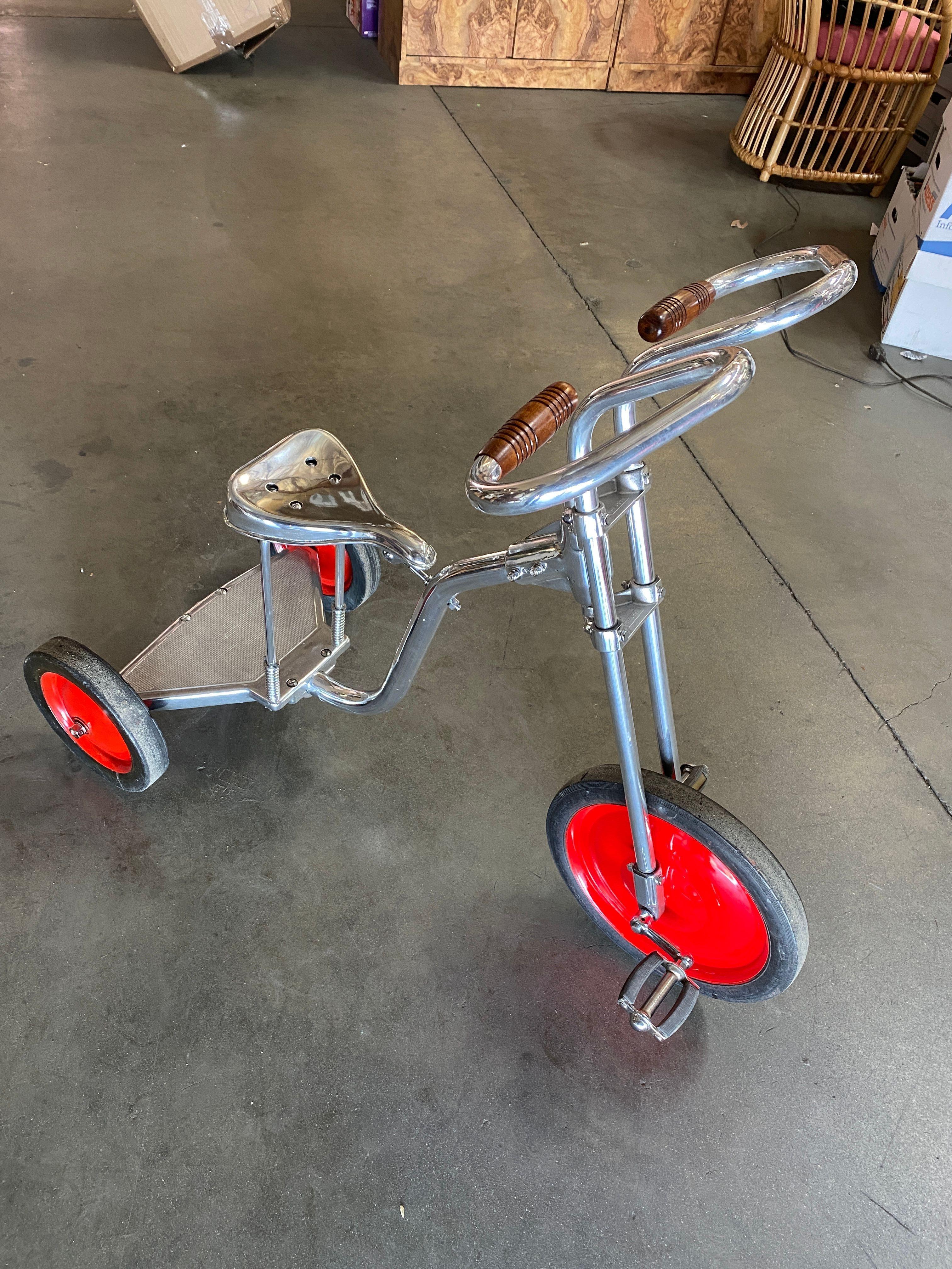 Circa 1940 is polished to chrome steel with walnut-finished handlebars in the style of Bowden Tricycle.
 
This large tricycle with easy fit a small adult 5' 6