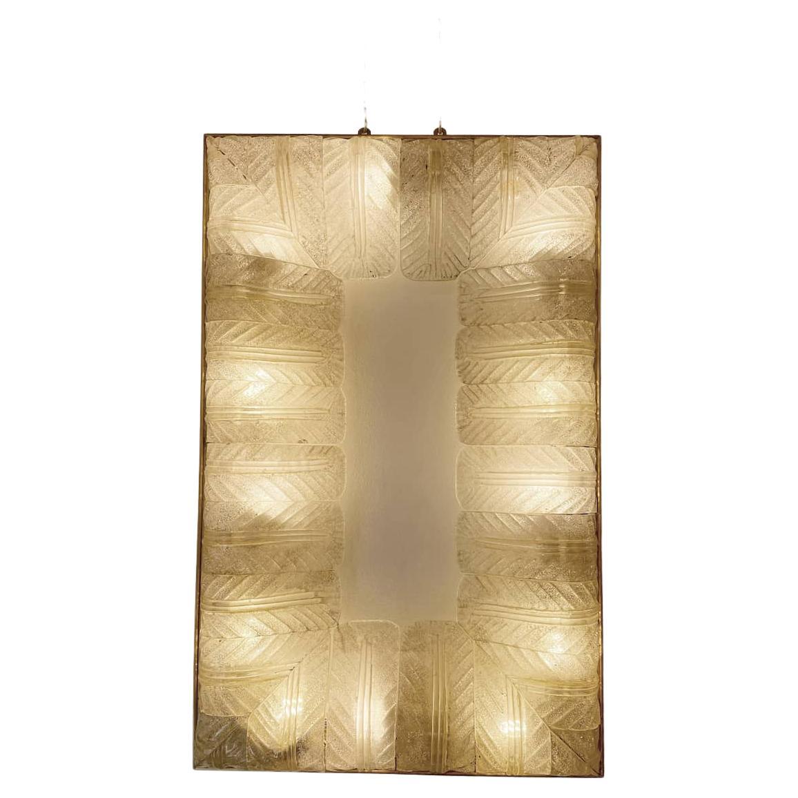 White glass wall sconce with golden spangles and brass border by Barovier & Toso, 1940s. The glass of the wall lamp has been worked in such a way as to create leaves that start from the outside on the outside and shrink towards the
