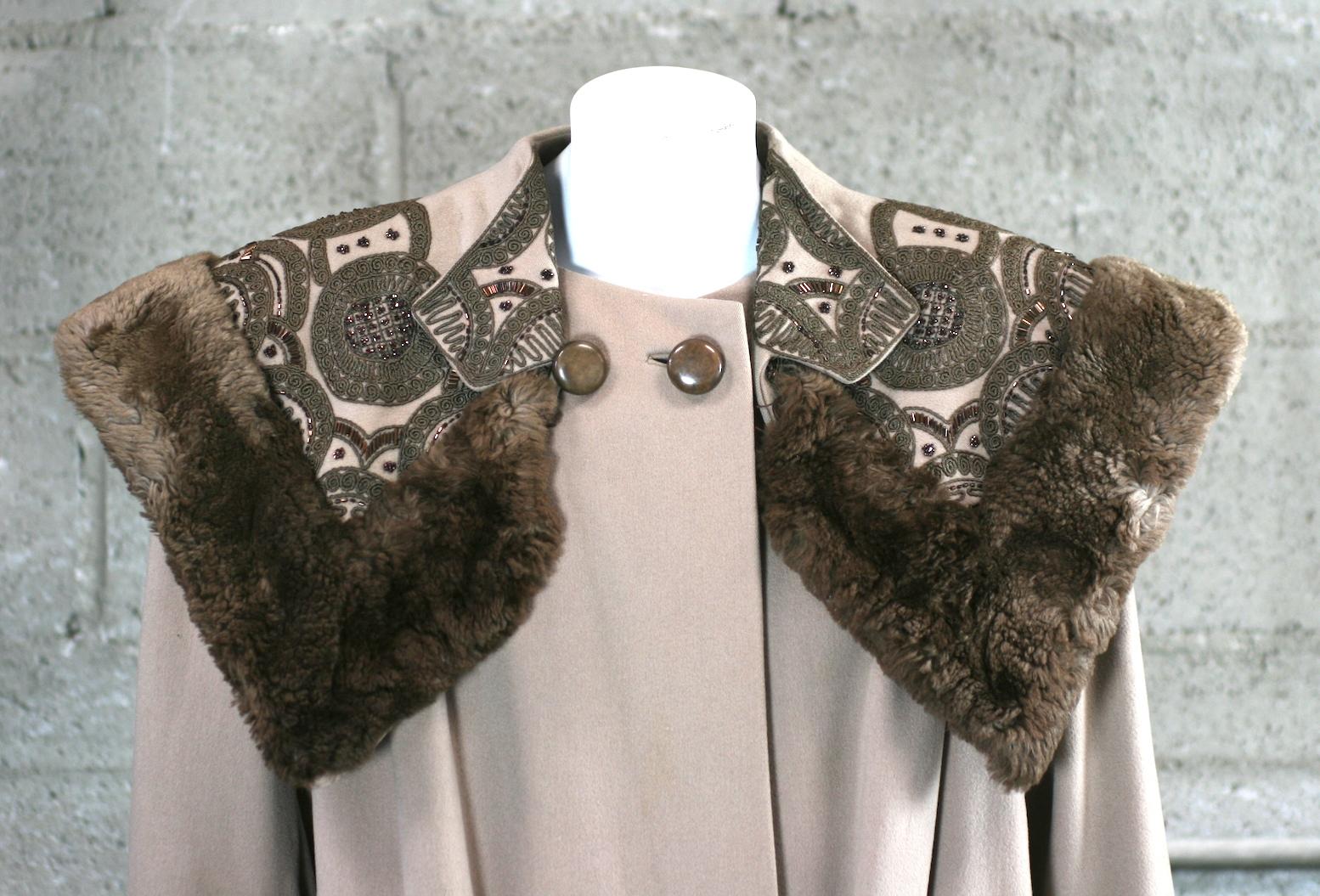 Glamorous Beaded and Mouton Trimmed Fawn Wool Coat from the 1940's with elaborate soutache embroidery and copper beading on cape and pockets. Satin lining.
Capelet once was tacked on but has been detached. (We can reattach if requested.) 
Large,