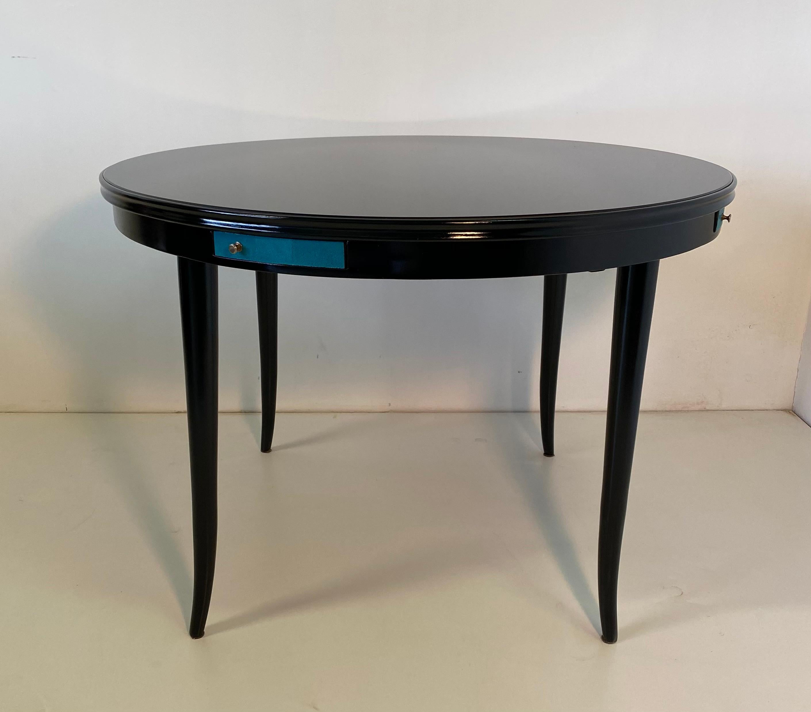 This game table was produced in the 1940s in Italy.
It is completely black lacquered with four drawers covered in blue shagreen.
The original top is in black glass while the handles and ashtrays are in brass.
Completely restored with some slight