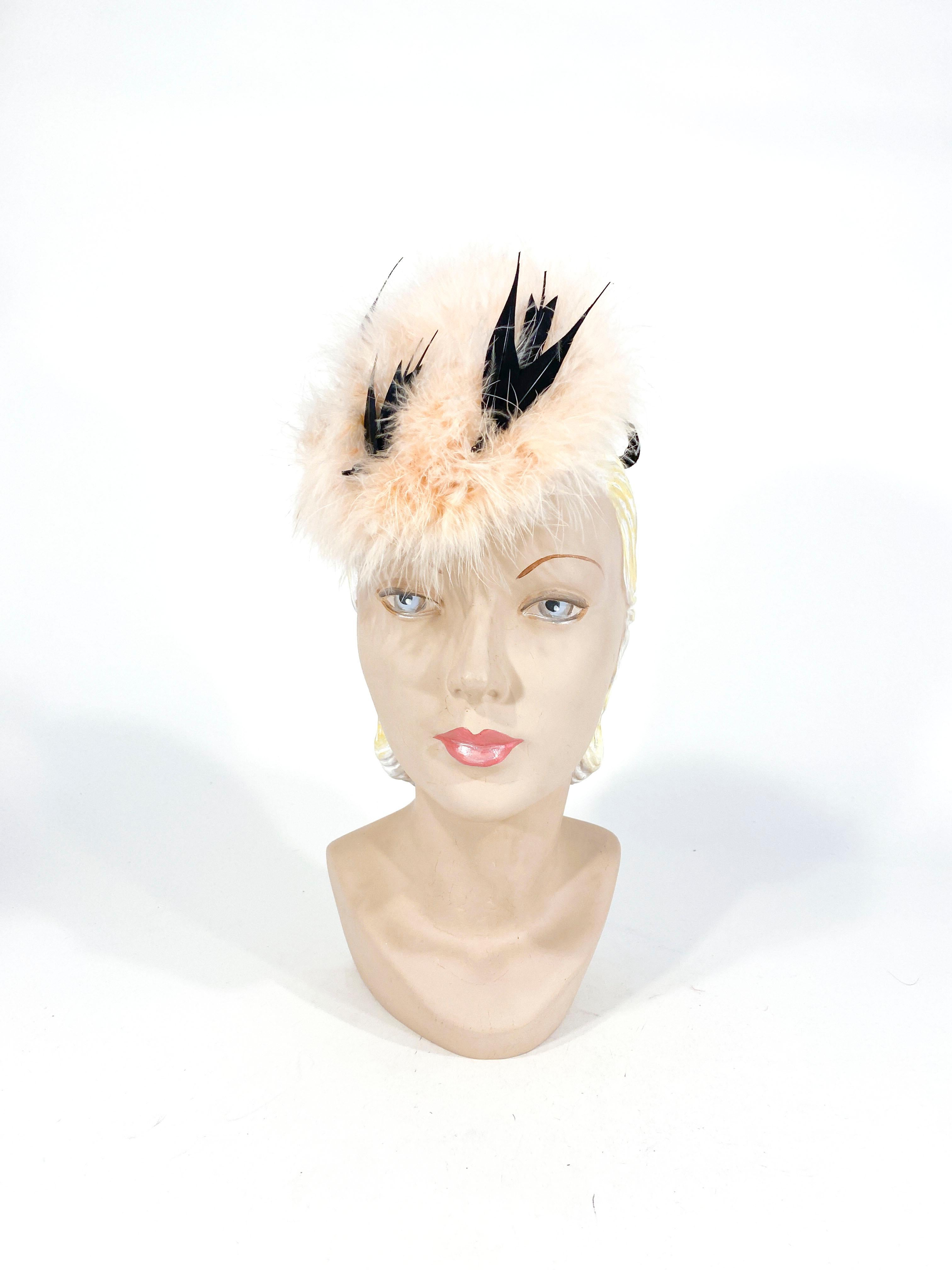 Early 1940s perch cocktail hat decorated with a nest of pink marabou feathers nesting three hand sculpted black birds. The hat is lined in a pink satin and the security ring covered in black wool felt fixes the hat to the head. 