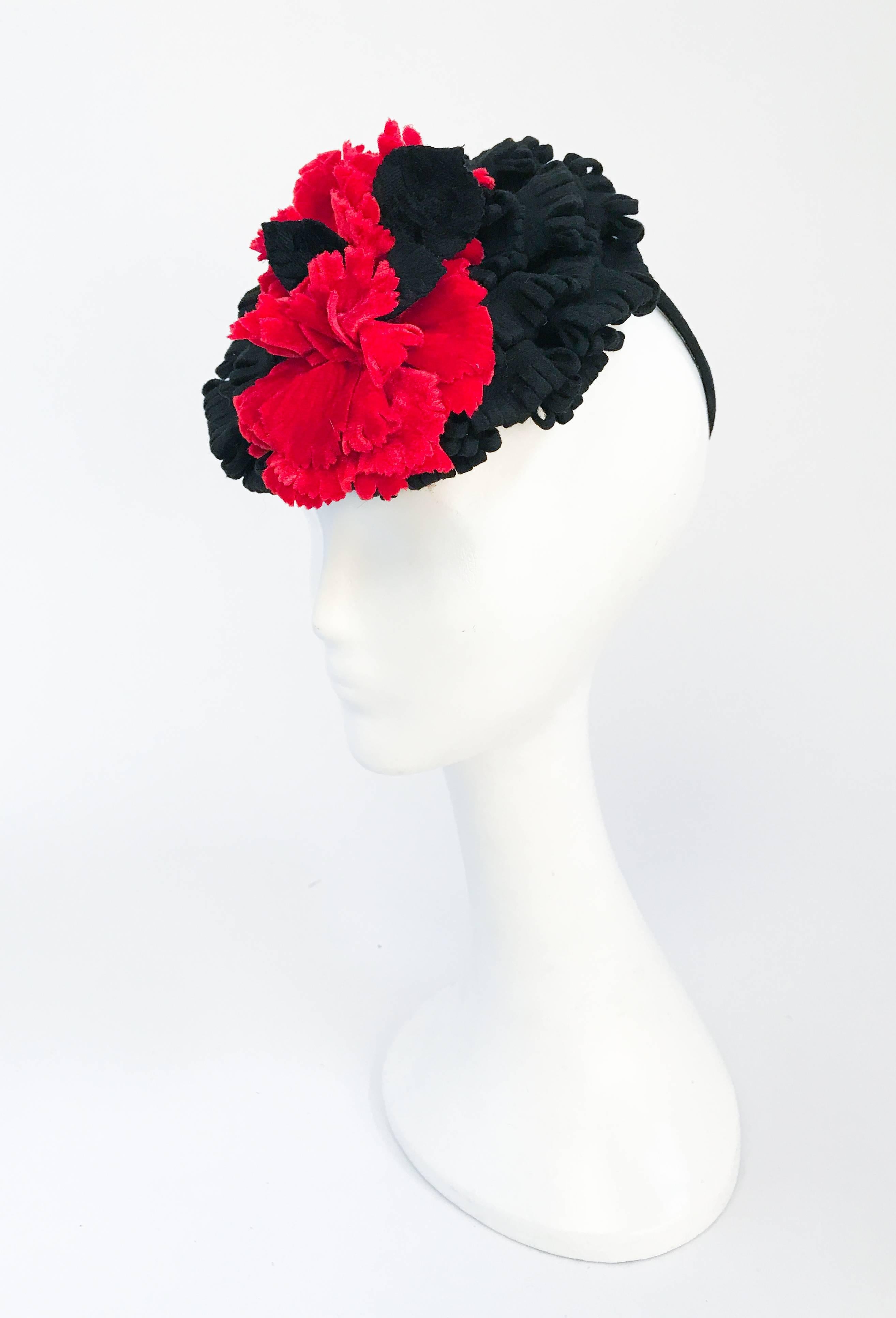 This exquisite handmade 1940s Black and Red Cocktail hat has red and black hand cut scalloped velvet accents. The body of the hat is made of a black fur felt. It has the original covered security loop for the back of the head meaning it can be worn