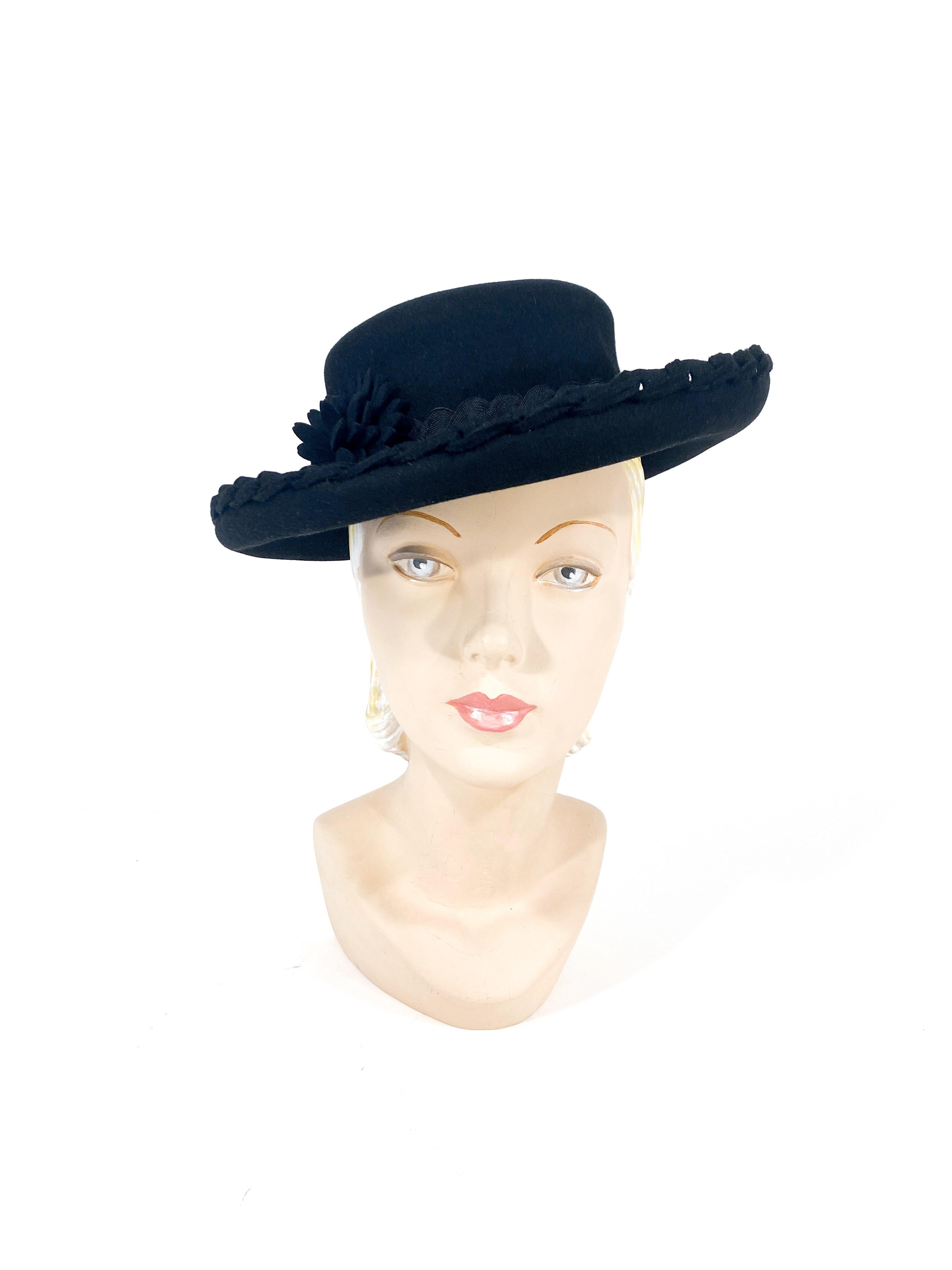 1940s black cashmere felt pork pie hat with rolled brim decorated with hand-braided trim, double bric-brac band, and a hand sculpted flower. The interior has the original price tag.