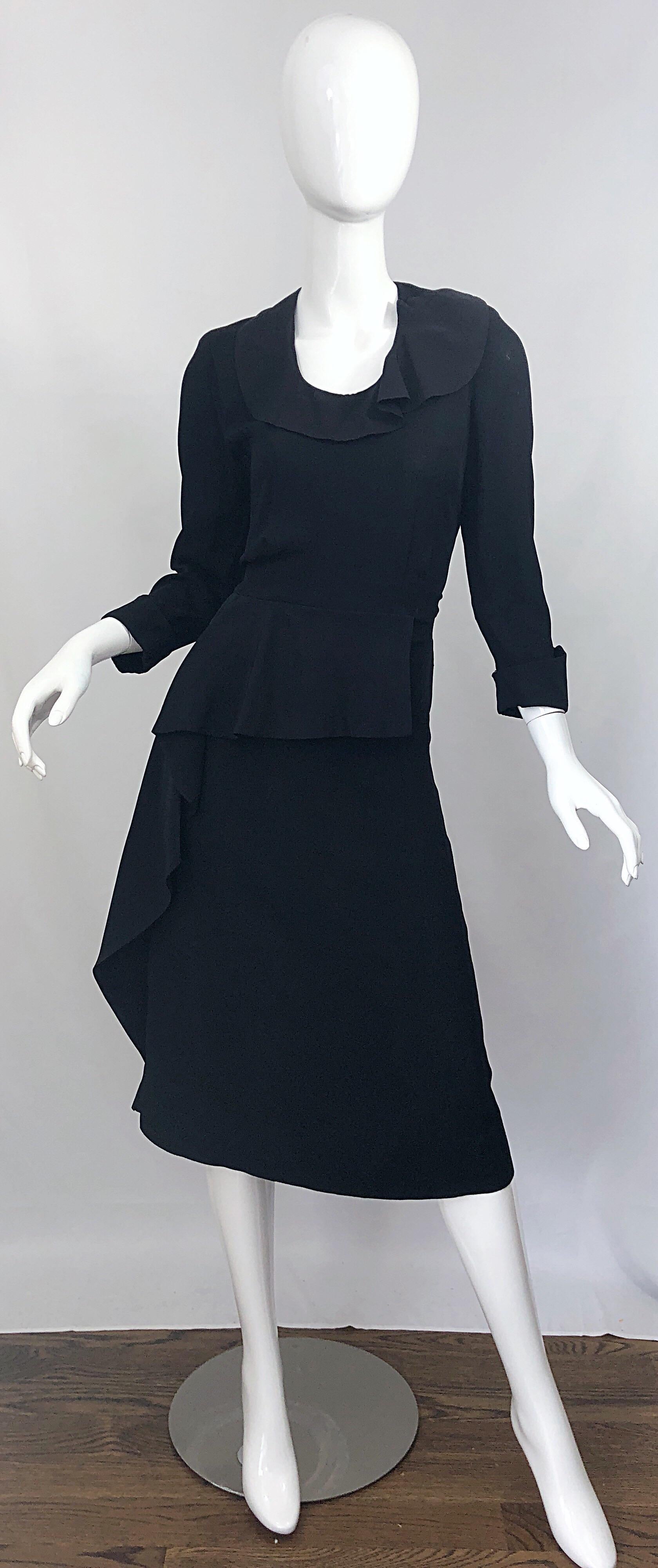 Chic 1940s schwarzer Krepp lange Ärmel Vintage 40s asymmetrische Schößchen Kleid! Das perfekte kleine Schwarze, das Klasse und Stil ausstrahlt. Schmeichelhaftes seitliches Schößchen-Detail, mit Rüsche an Taille und Kragen. Metallreißverschluss an