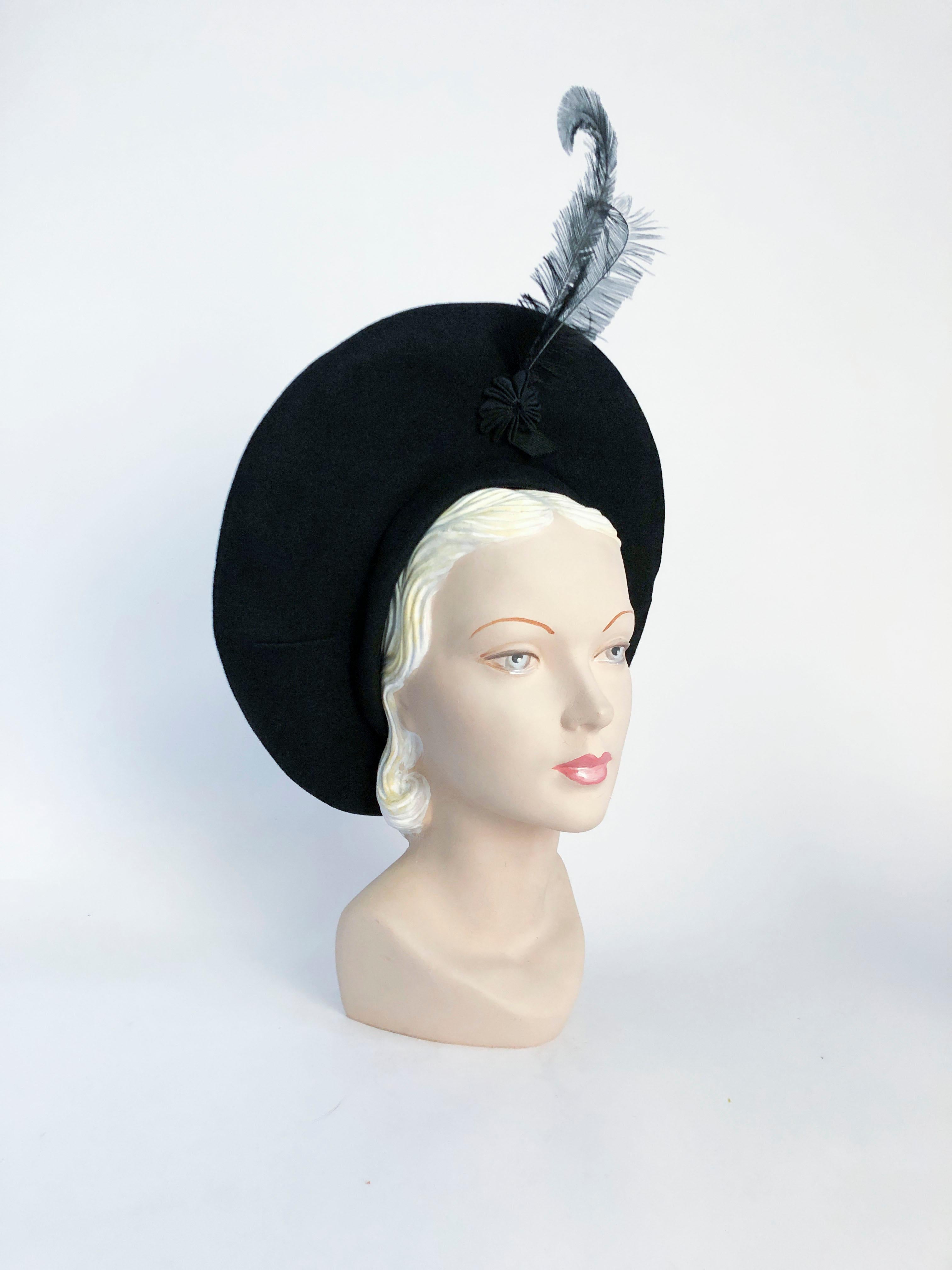 1940s Black fur felt pancake hat with a grosgrain star anise accent finished with a had curled lack feather
