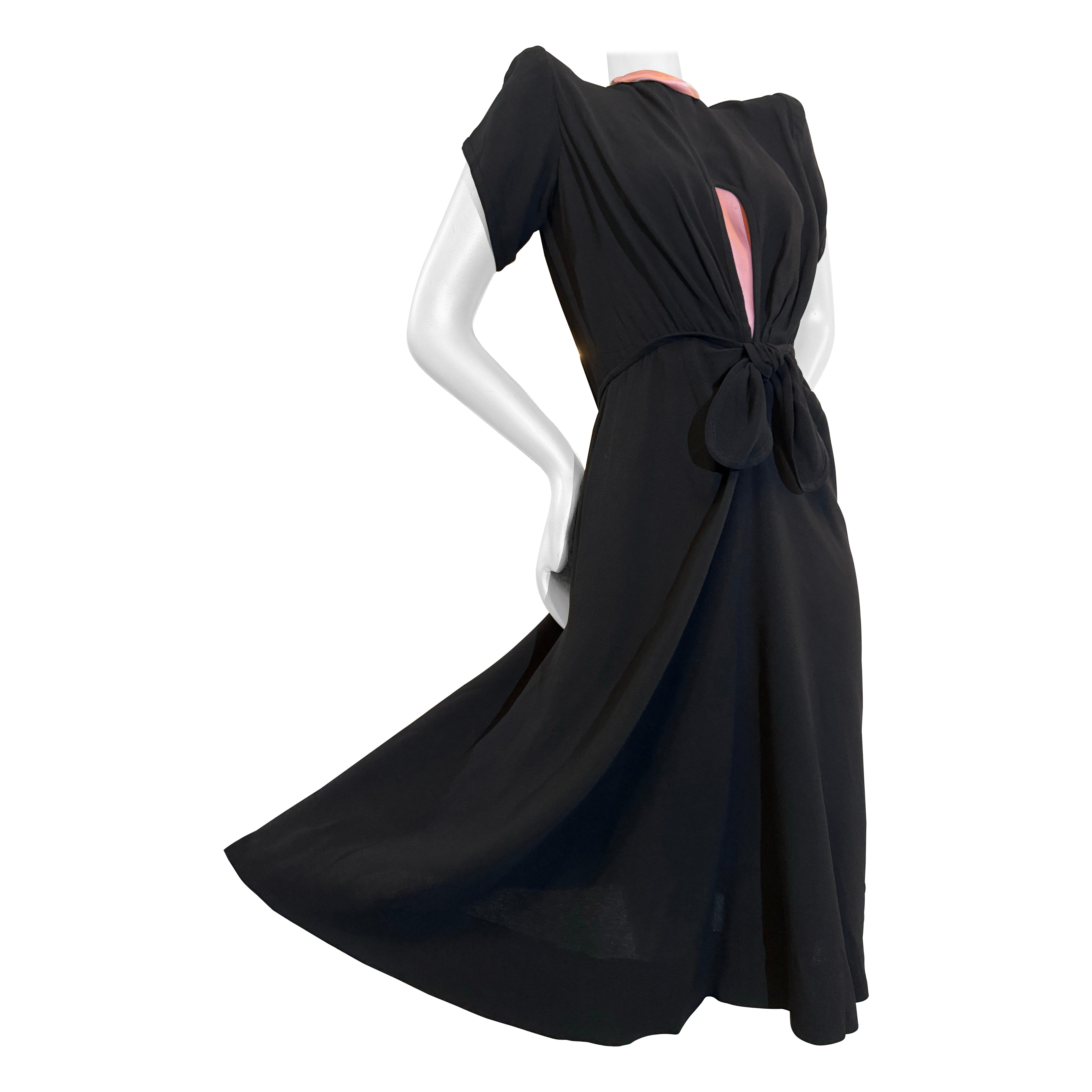 1940s  Robe de cocktail en crêpe de rayonne noir avec découpe en trou de serrure, nœud à la taille et bordure rose en vente