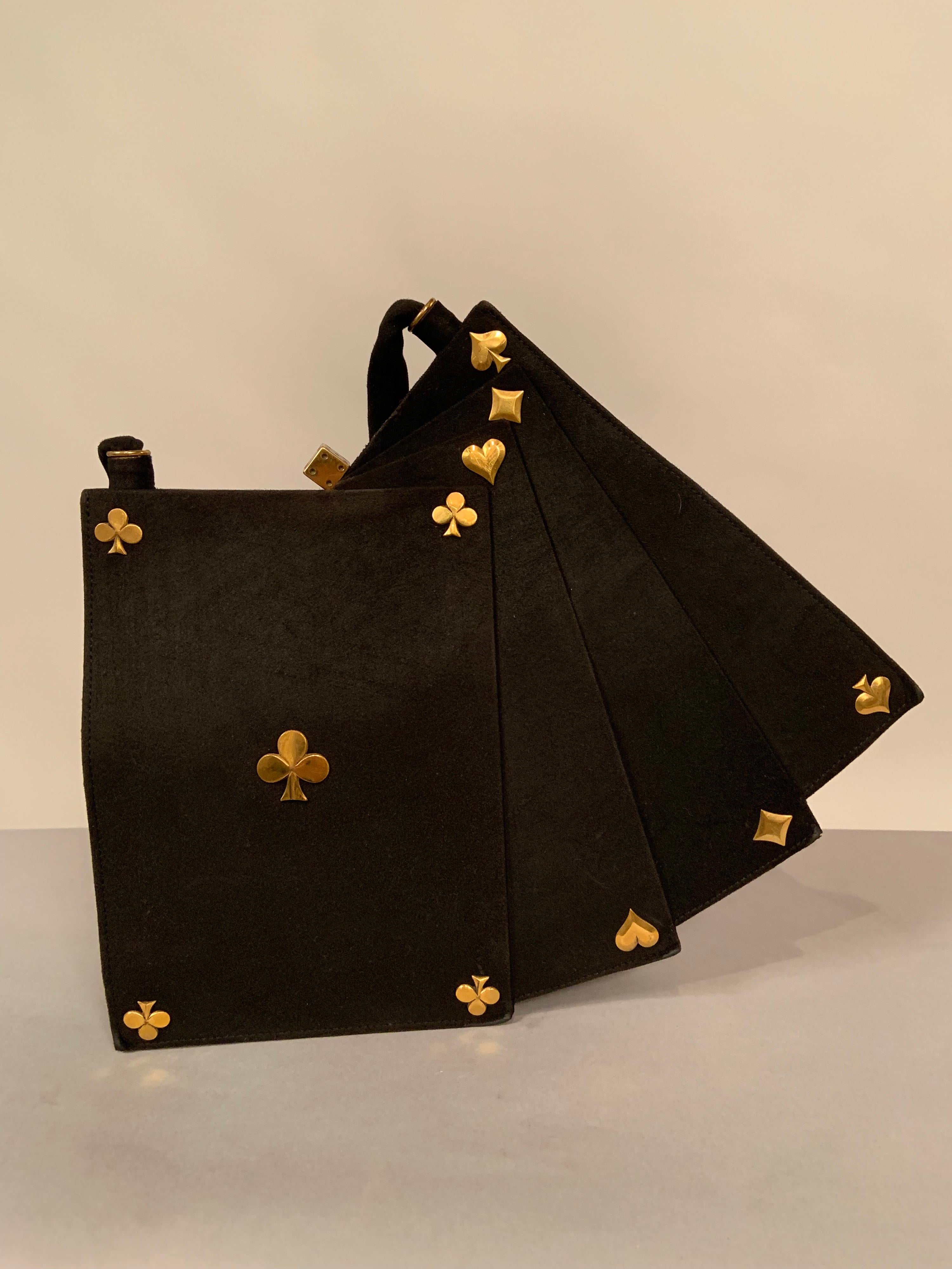 This charming and witty bag was most likely designed by Anne Marie, Paris a designer specialising in bags shaped like playing cards, fans, ice buckets and champagne bottles. It is not labelled though. The bag is black suede with gold toned